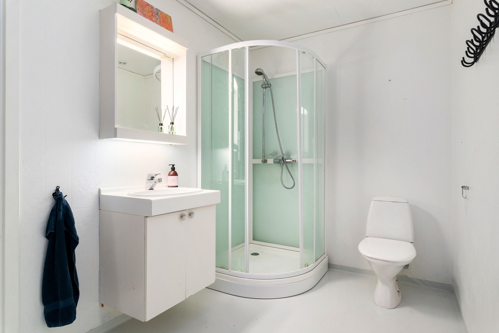 Bad/vaskerom er innredet med innredning med servant, toalett og dusjkabinett. Galleribilde