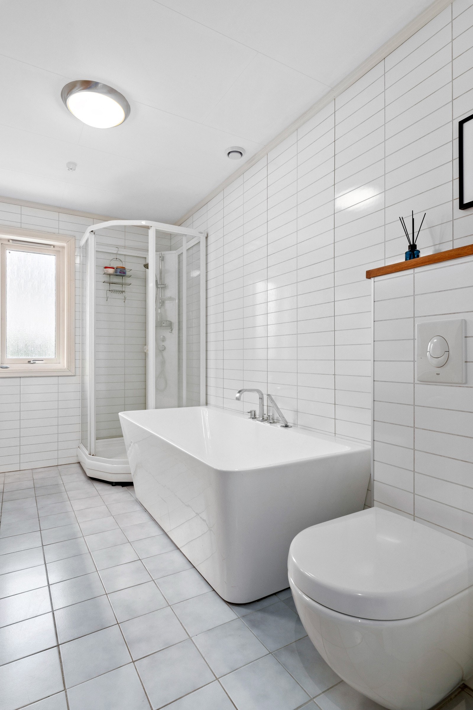 Innredet med servant, dusjkabinett, badekar og vegghengt wc. Galleribilde