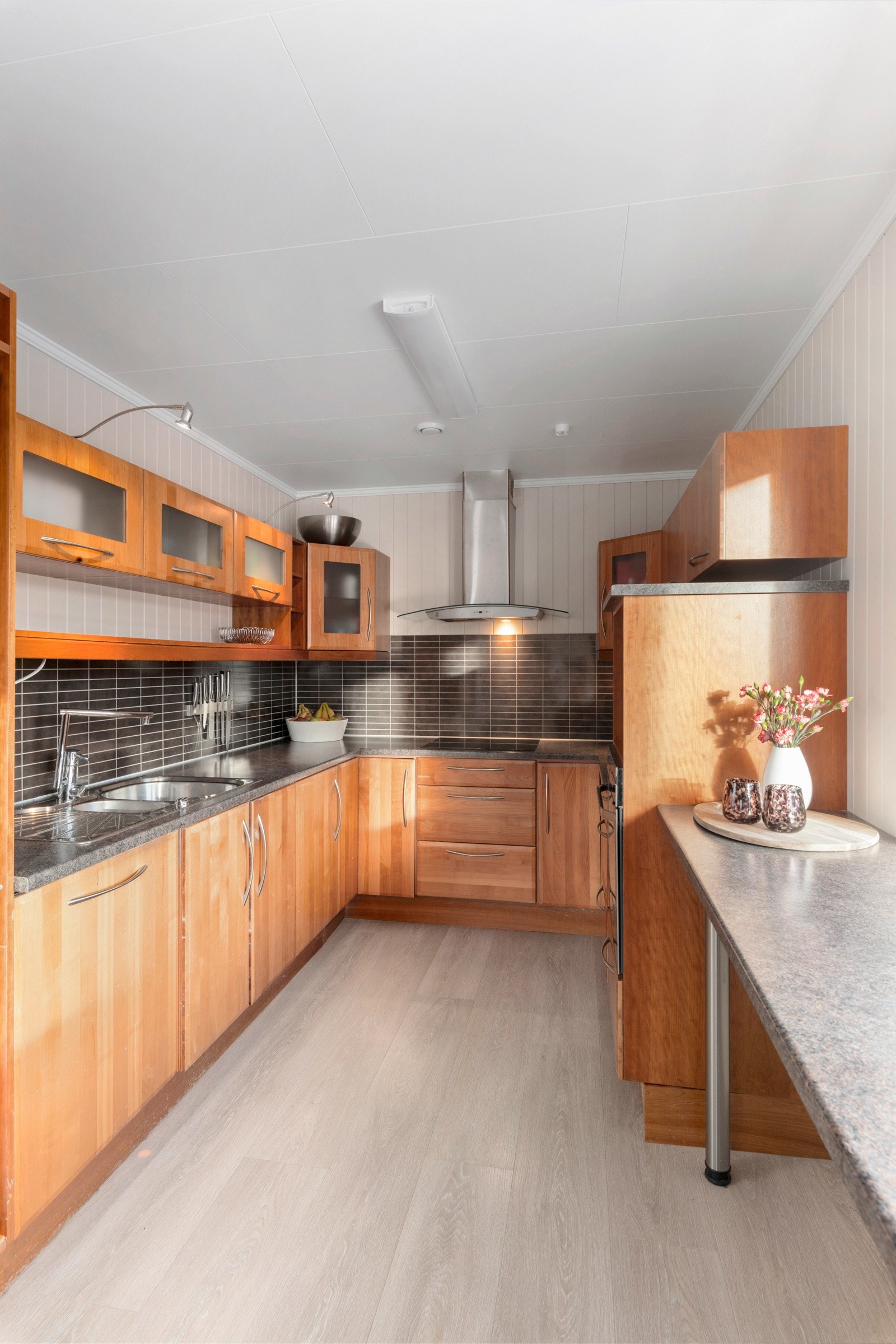 Kjøkkeninnredningen har fronter i kirsebærtre og laminert benkeplate. Galleribilde