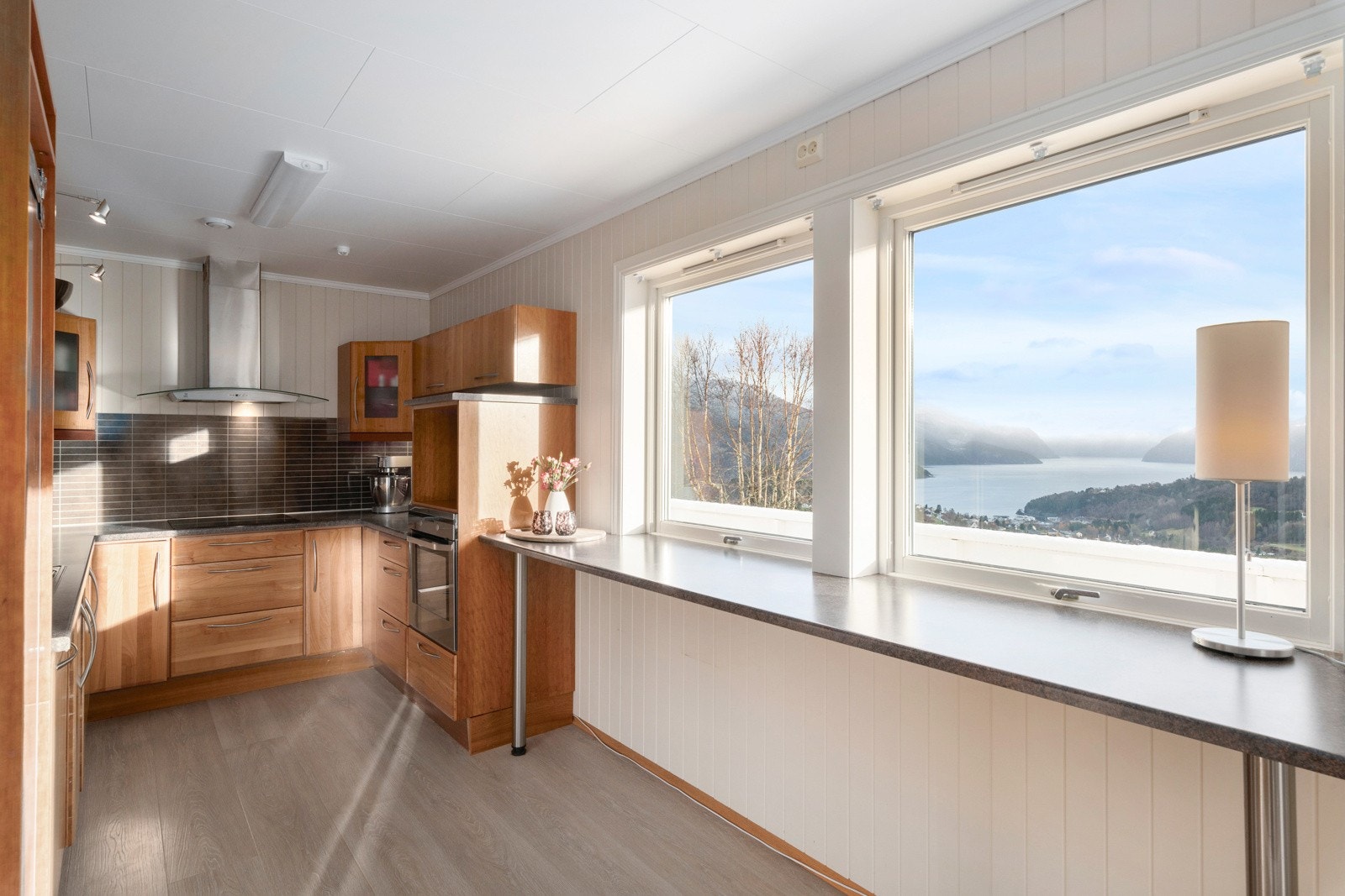 Kjøkkenet er romslig og har mye skap- og benkeplass. Fin barløsning ved vinduet. Galleribilde