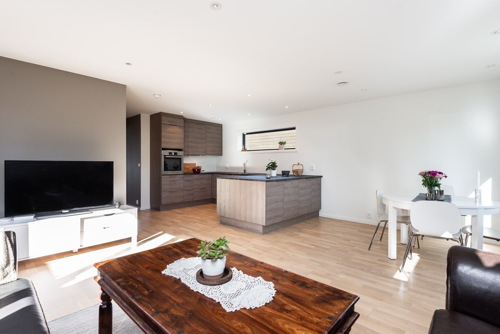 Integrerte hvitevarer, inkludert kjøleskuffer og stekeovn, gir et helhetlig kjøkken. Galleribilde