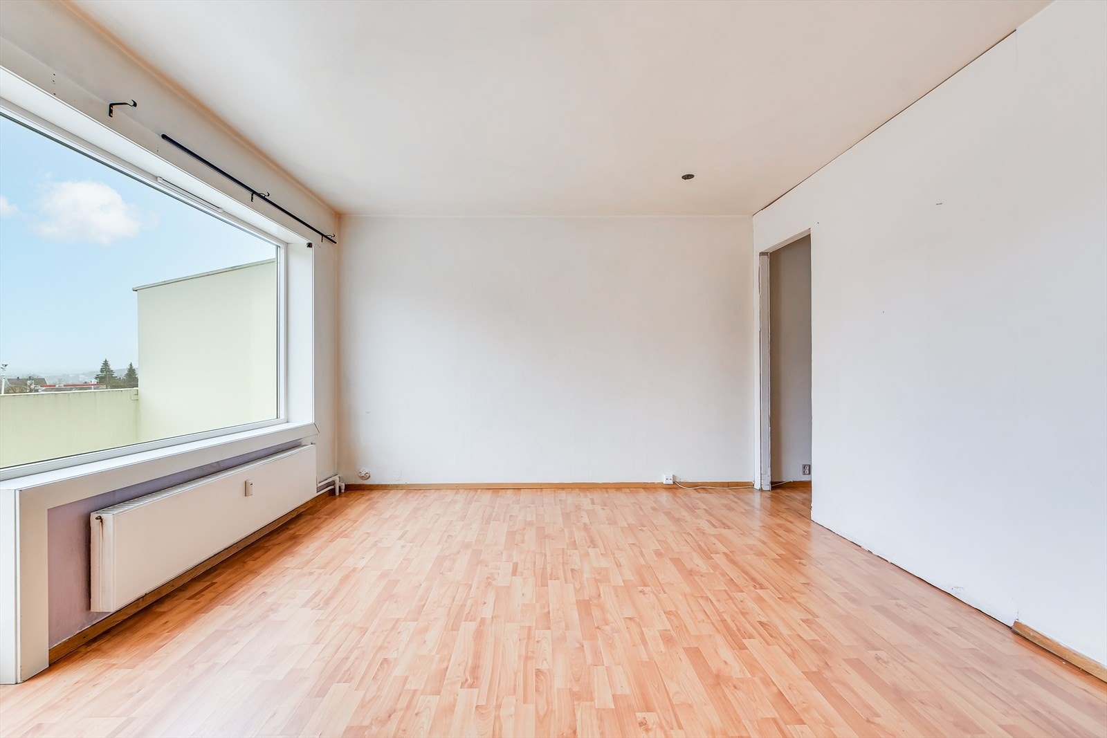 Romslig stueløsning med plass for sofagruppe, spisebord og annet møblement. Galleribilde