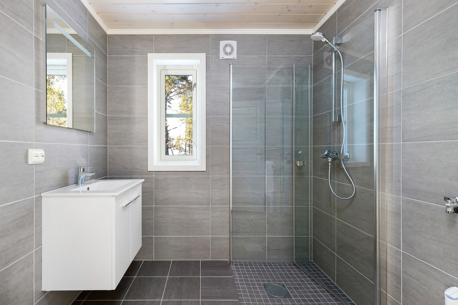 Badet inneholder WC, innsvingbar dusjvegger i herdet glass og 60 cm baderomsinnredning i hvit utførelse med dempeskuffer og hel servantplate. Bildet er ikke av selve hytta. Galleribilde