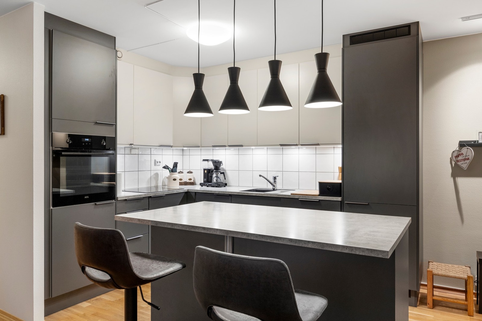 Stilren og moderne kjøkkeninnredning med tilhørende kjøkkenøy Galleribilde