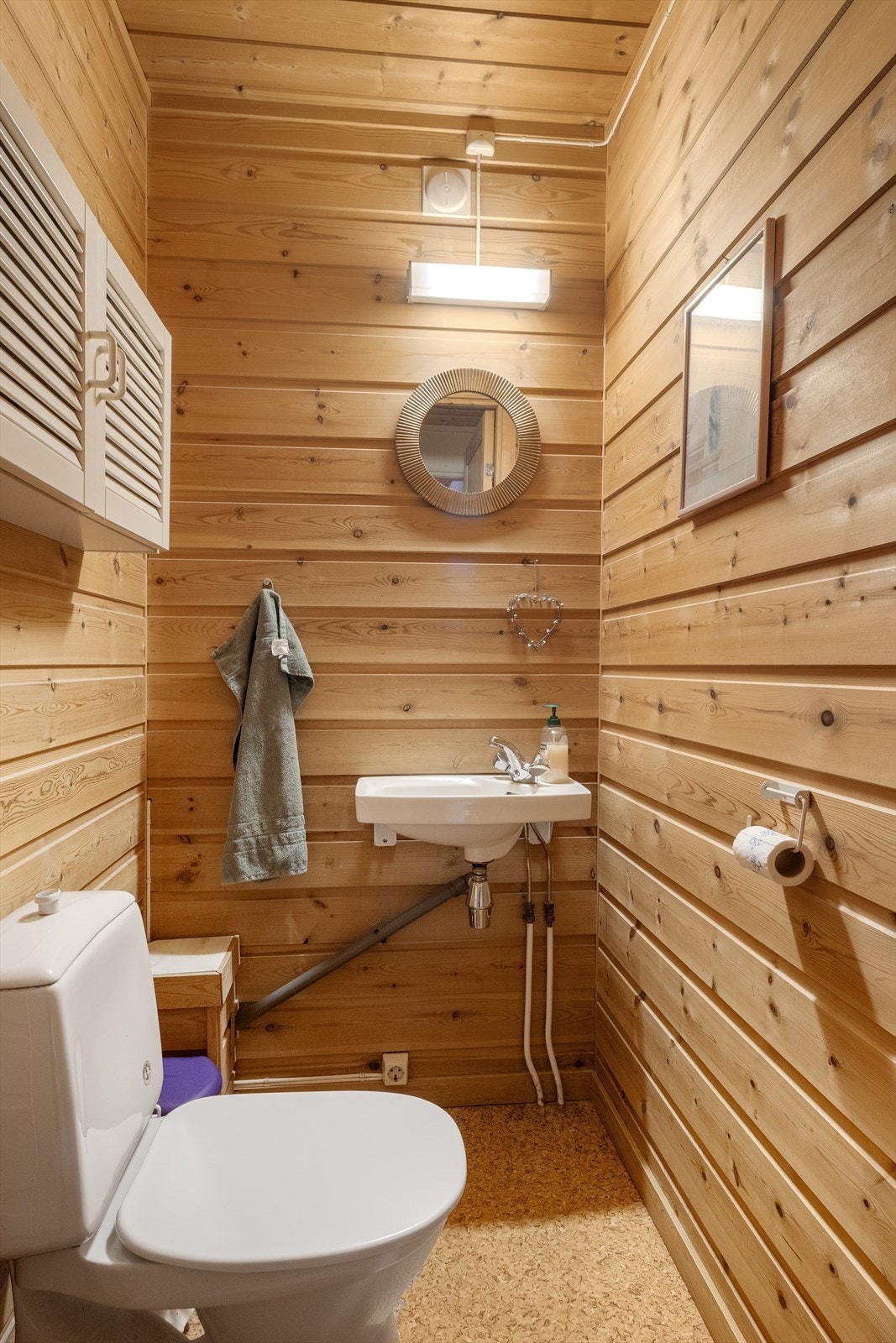 Praktisk toalettrom med vegghengt servant og gulvmontert toalett. Galleribilde