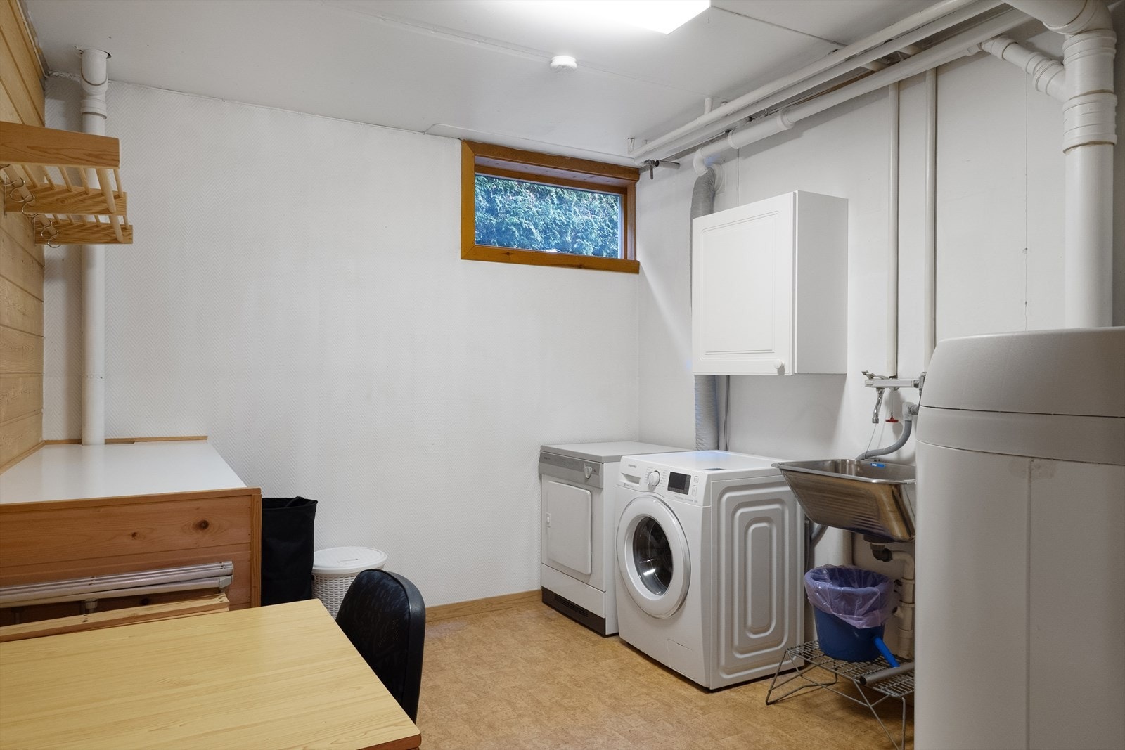 Vaskerom med utslagsvask, opplegg for vaskemaskin og plassbygget benk. Galleribilde