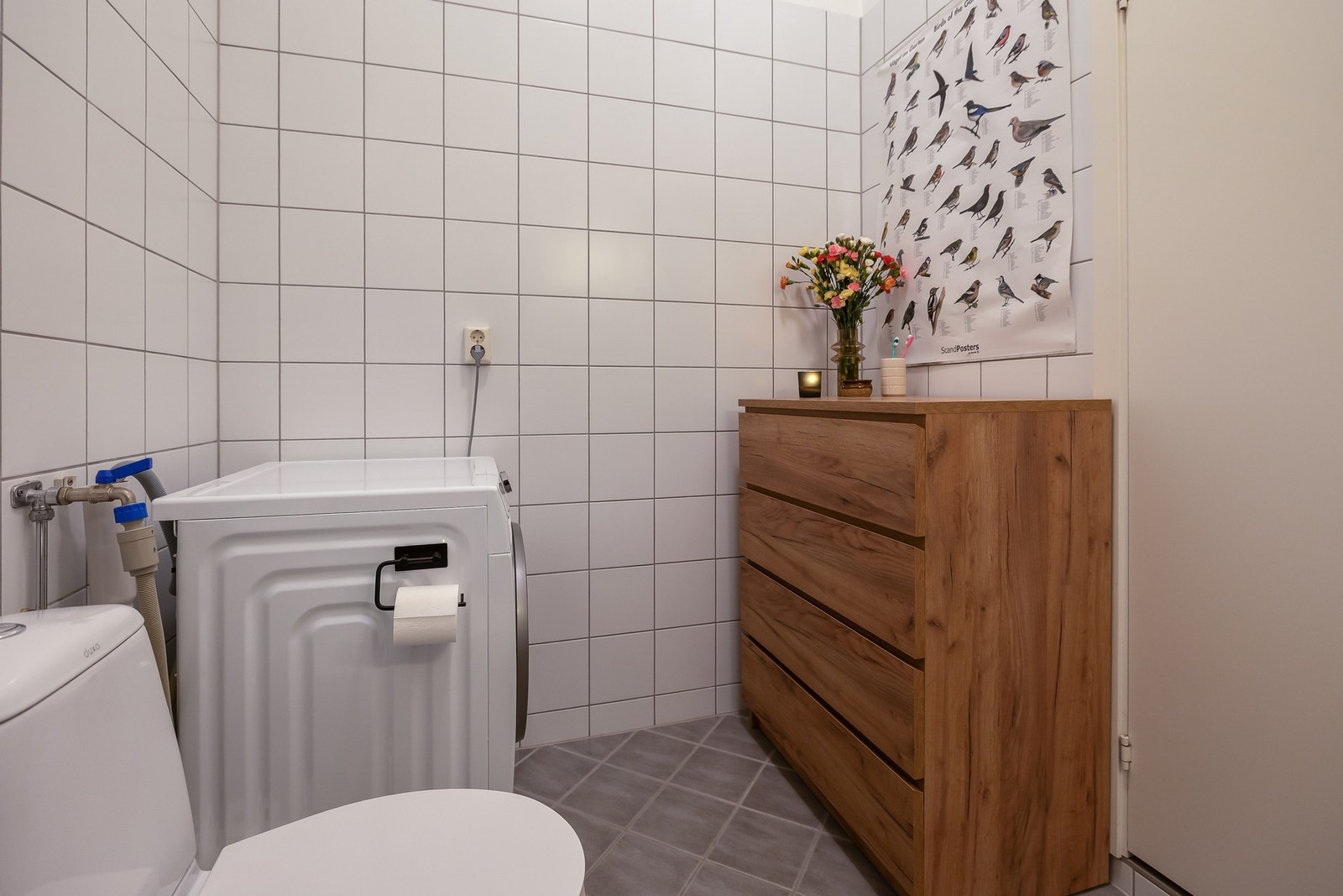 Baderommet inneholder dusjhjørne med dører, gulvstående toalett og opplegg for vaskemaskin. Galleribilde