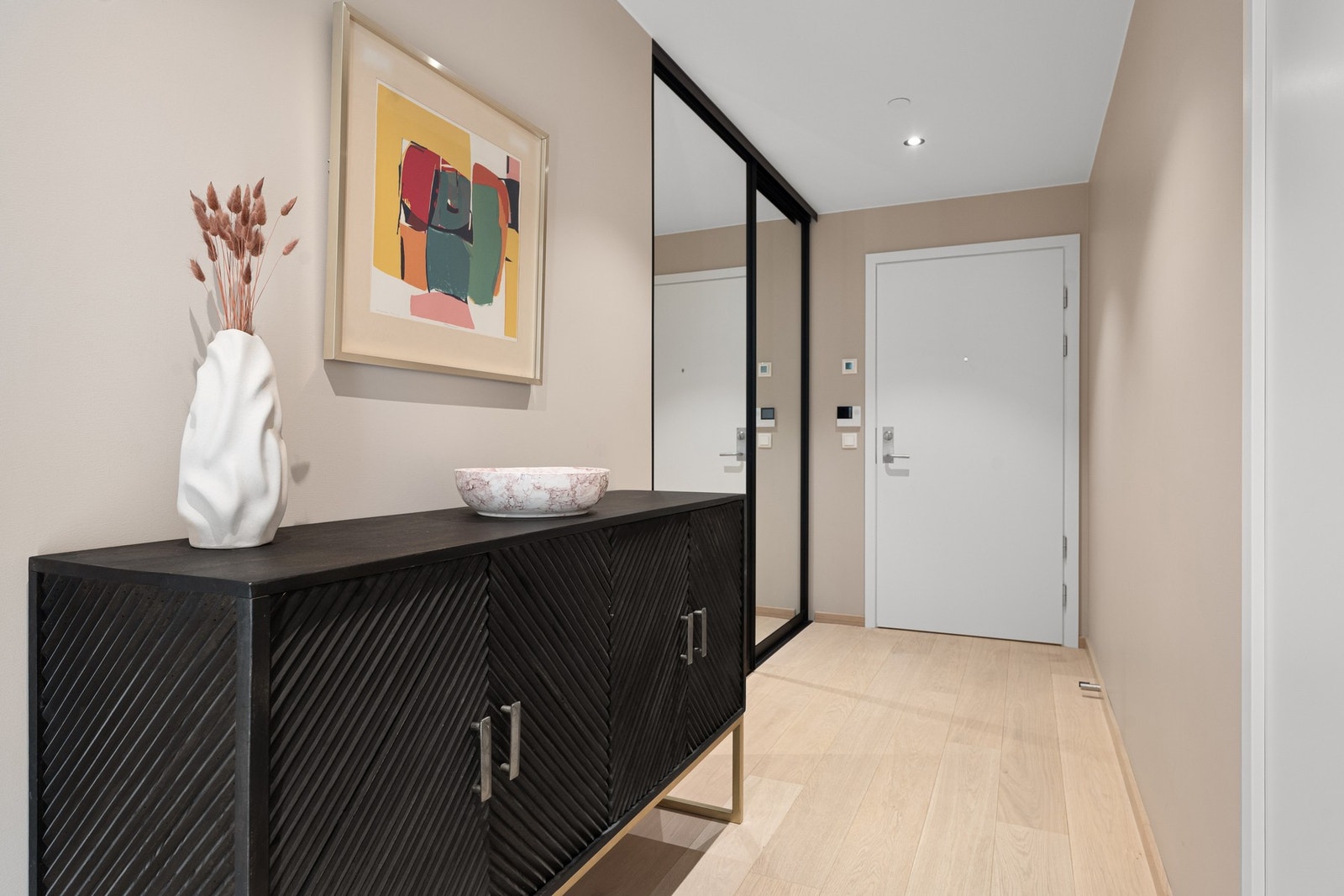 Garderobeløsning i gangen har skyvedører og store speilfronter og er måltilpasset oppgradering i boligen Galleribilde