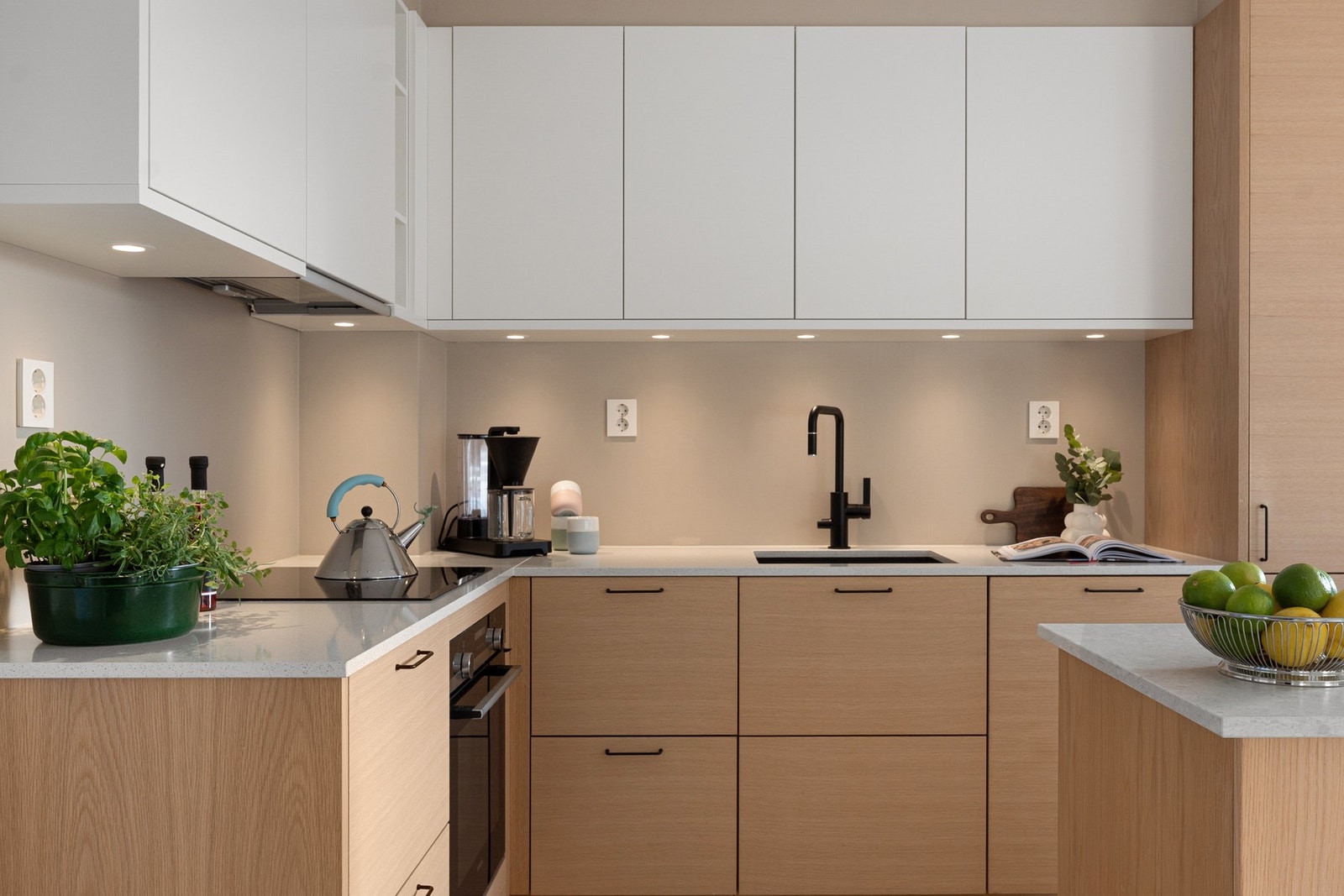 Innredningen har lys benkeplate i komposittstein. Svart oppvaskkum og armatur. Galleribilde