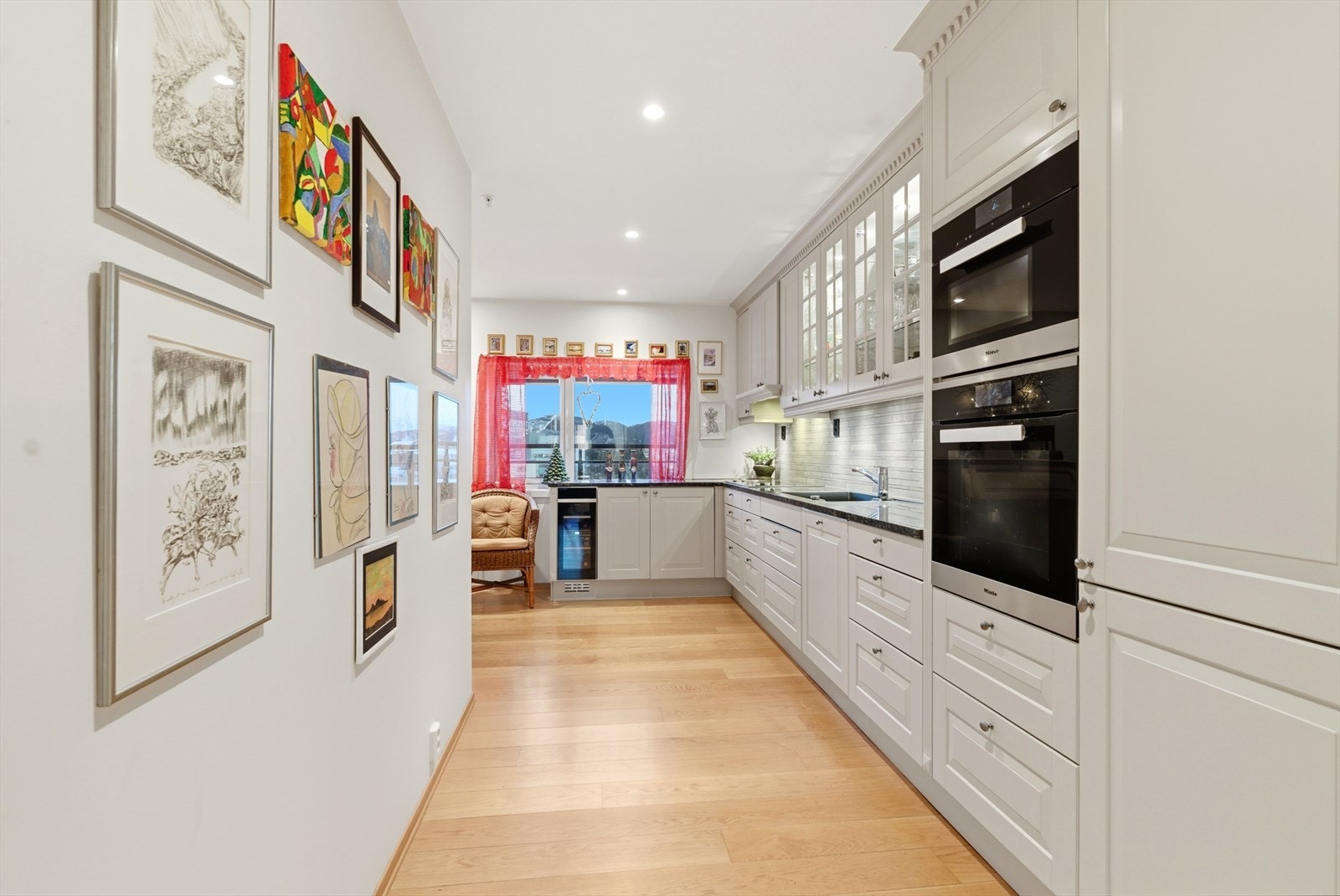 Lyst og tidløst Sigdal Herregaardskjøkken med profilerte fronter og benkeplate av solid stein. Galleribilde