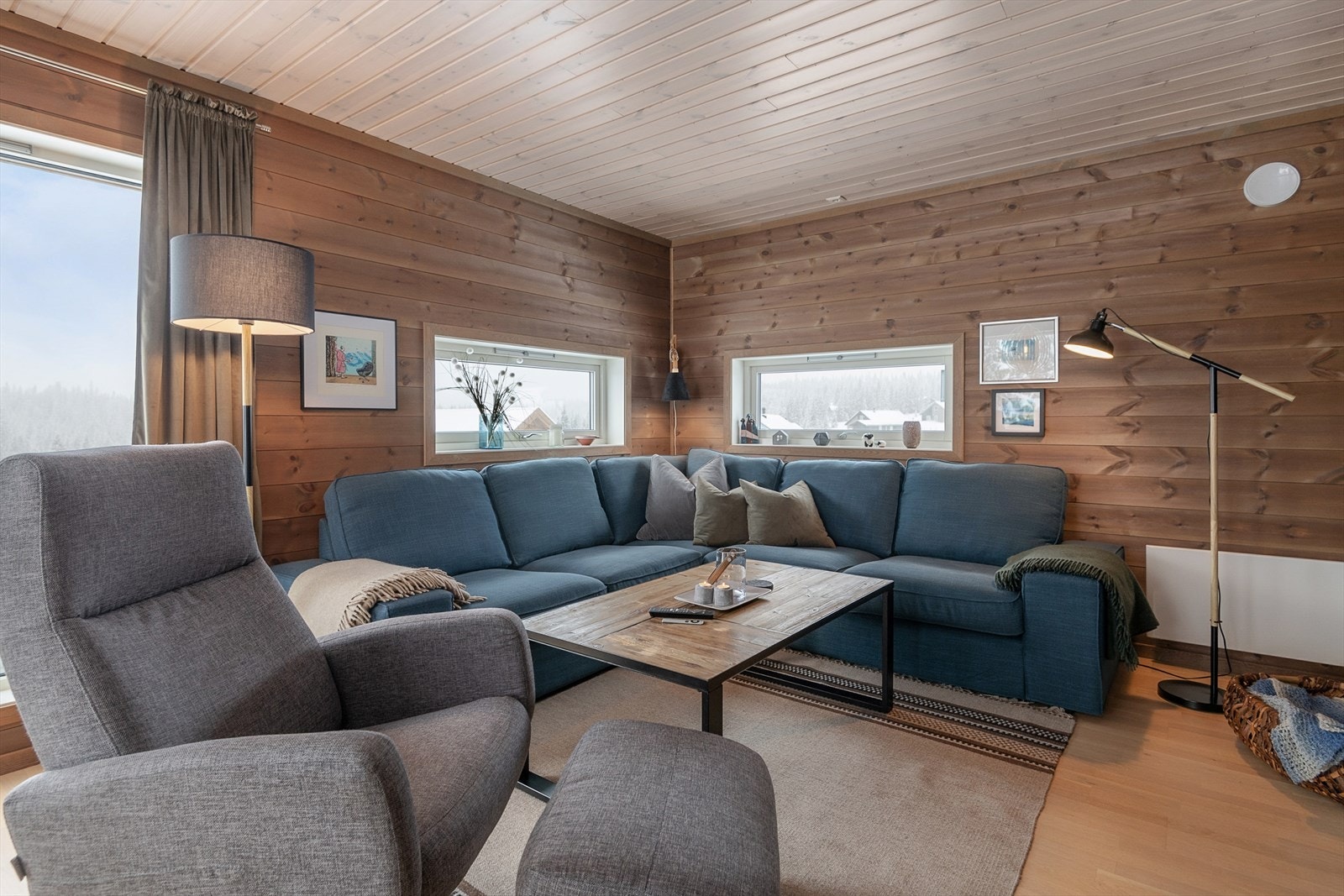 God plass til å møblere med sofa i stua. Fint lys kommer inn gjennom vinduene. Galleribilde