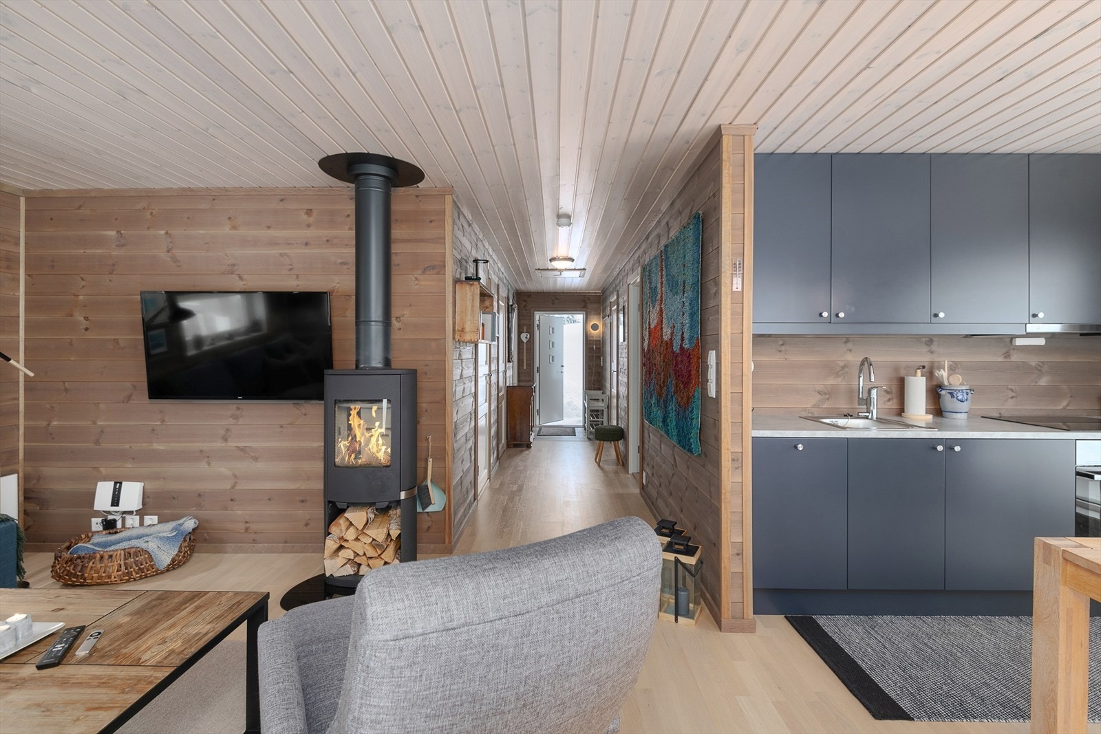 Gjennomført og helhetlig stil og standard i hytta. Beiset, liggende panel på vegger og hvitpigmentert panel i himling. Galleribilde