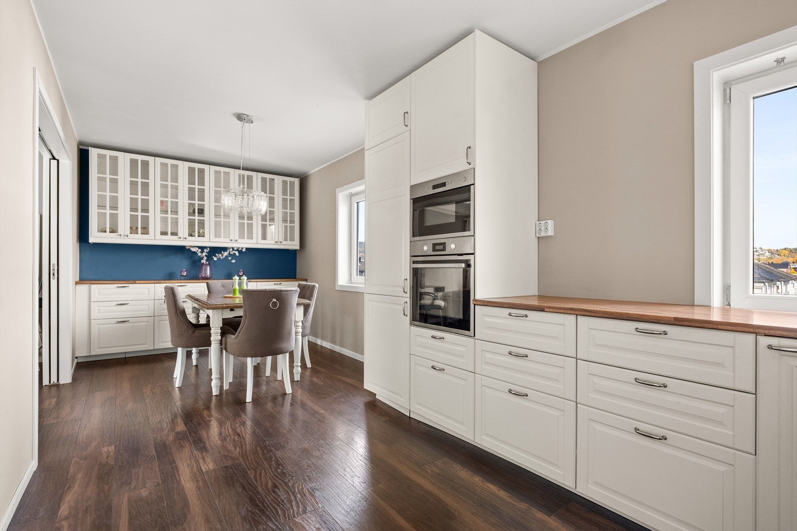 Pent kjøkken med profilerte fronter, flislagt over kjøkkenbenk og benkeplate i laminat Galleribilde