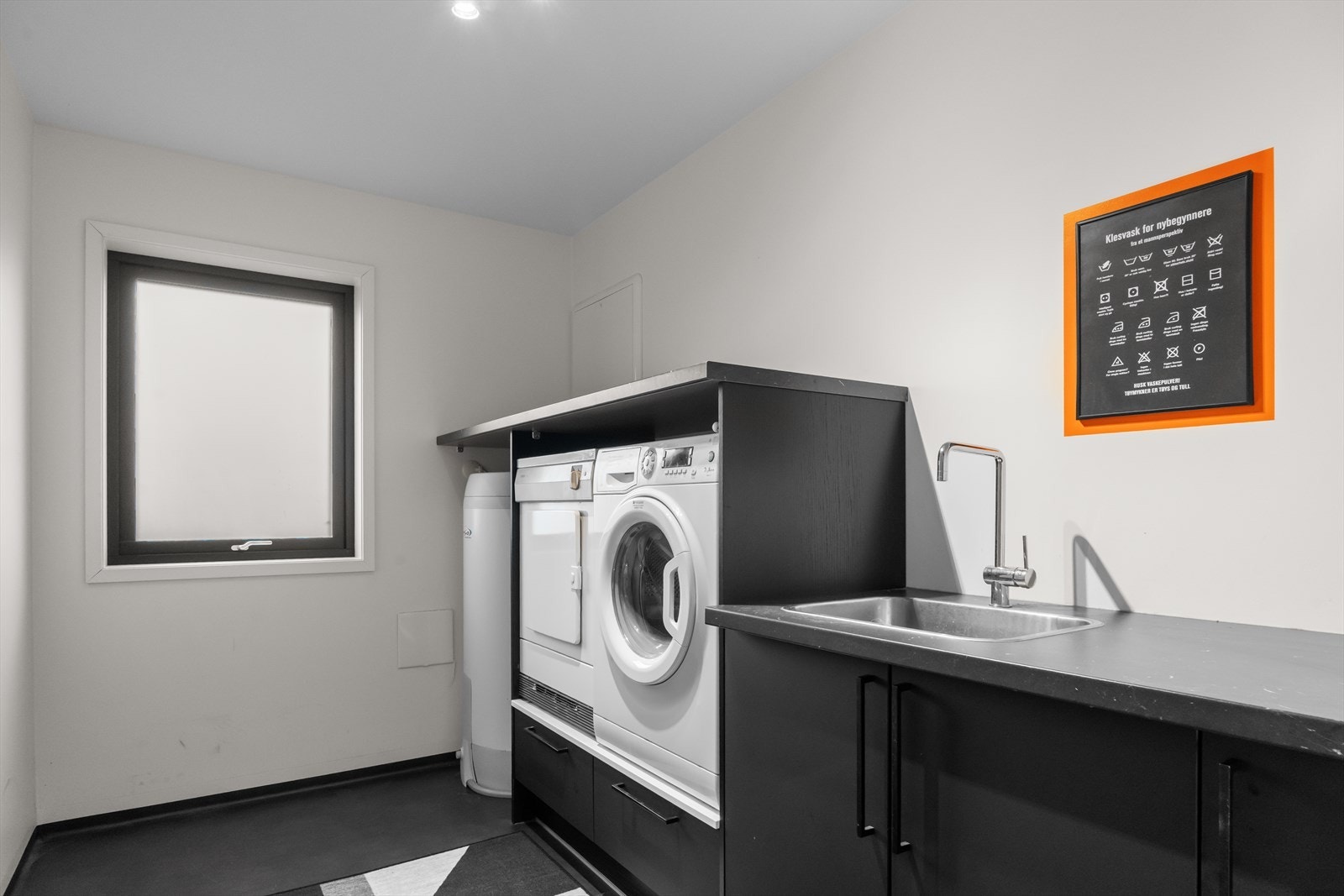 Vaskerom med praktisk innredning, opplegg for vaskemaskin og tørketrommel, samt god oppbevaringsplass. Galleribilde
