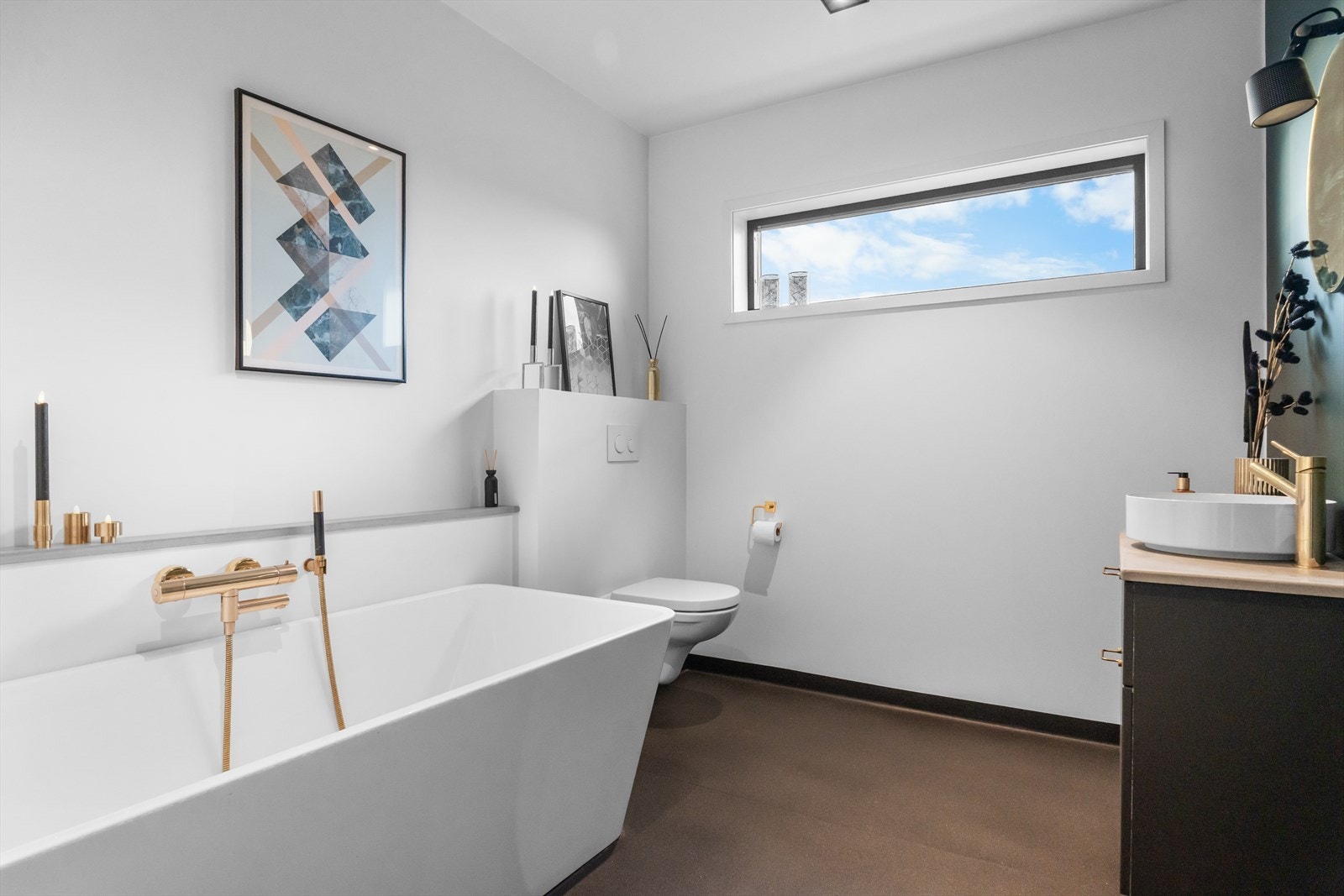 Lekkert bad med badekar, vegghengt toalett og skuffeseksjon med servant. Galleribilde