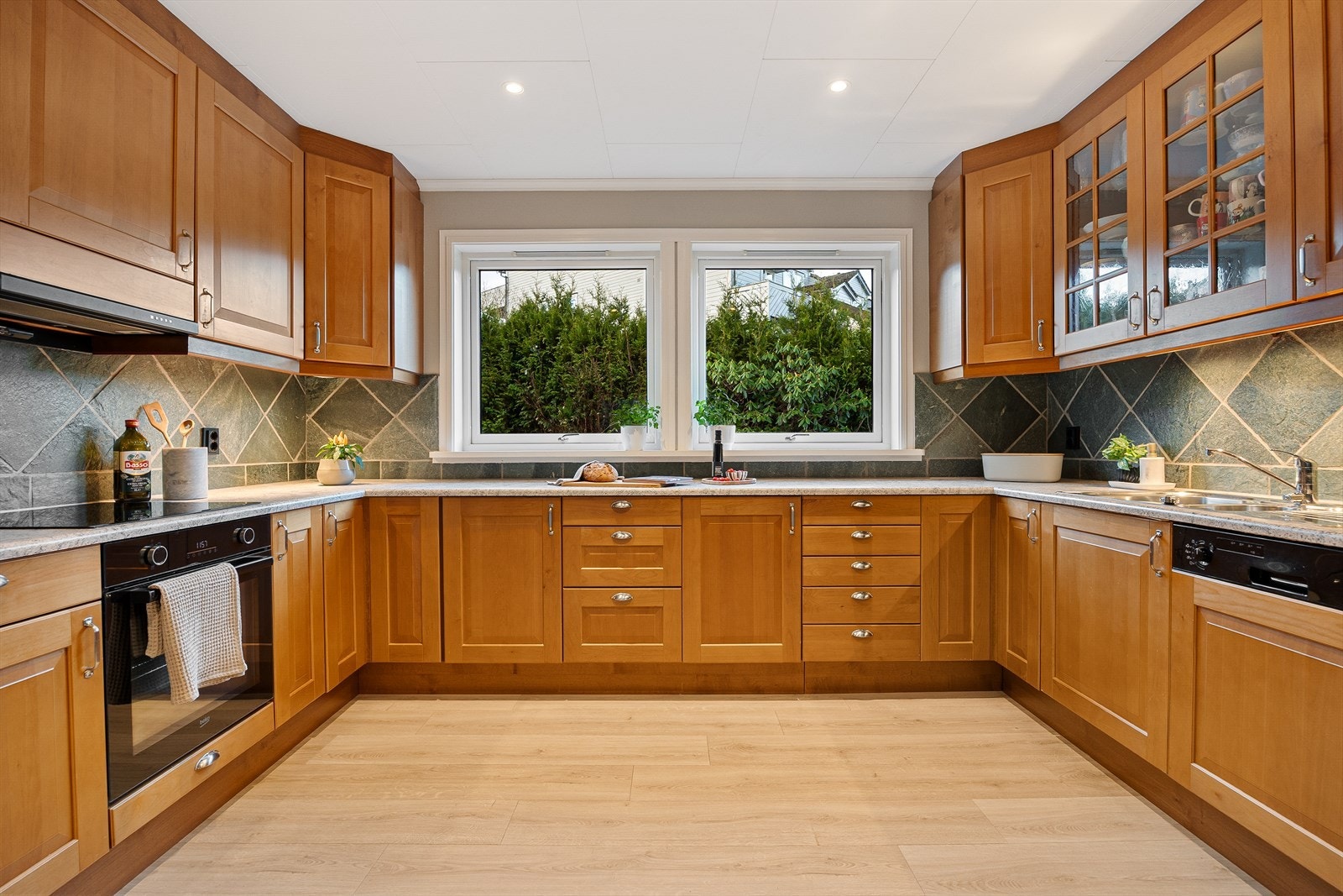 Kjøkkeninnredning med laminert benkeplate, nedfelt stålvask og profilerte fronter. Alle hvitevarer på kjøkkenet medfølger selvsagt. Galleribilde