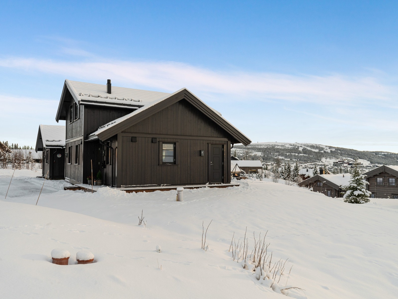 Det er montert ladestasjon for el-bil på hytteveggen. Galleribilde