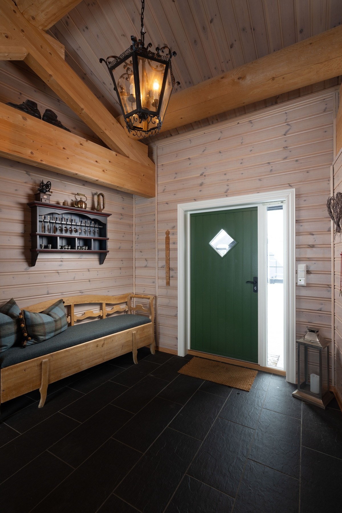 Romslig flislagt entré med inngang til egen garderobe. Galleribilde