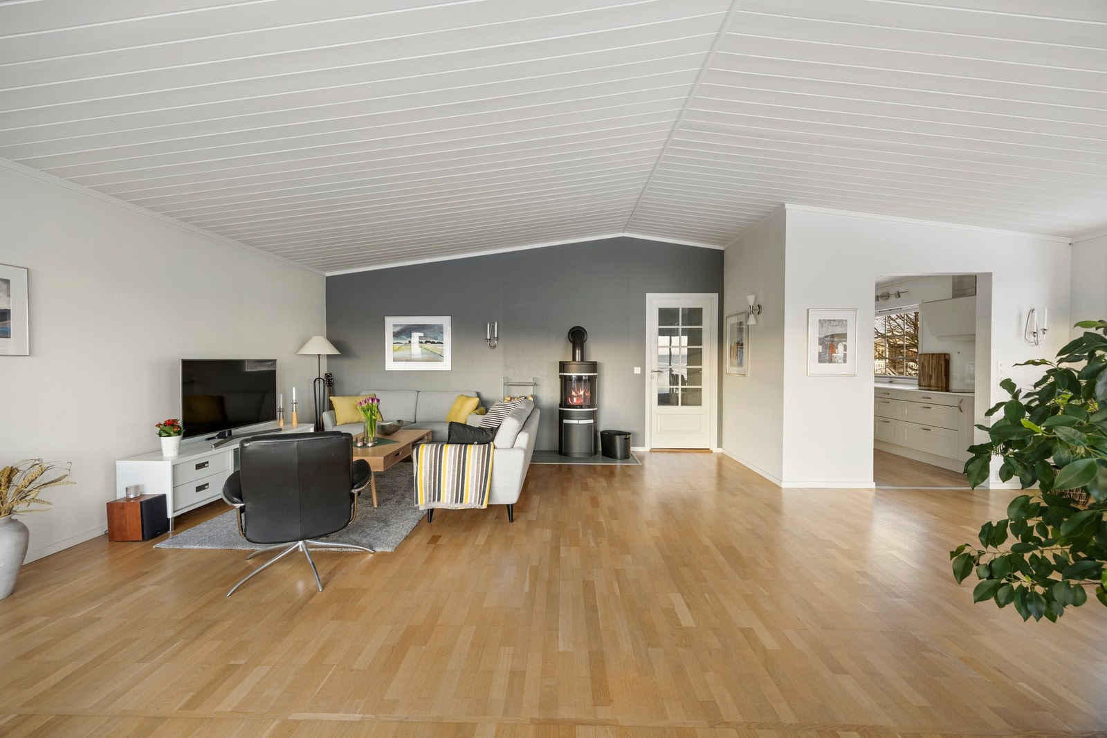 Det er installert både nyere varmepumpe og vedovn på stuen. Galleribilde