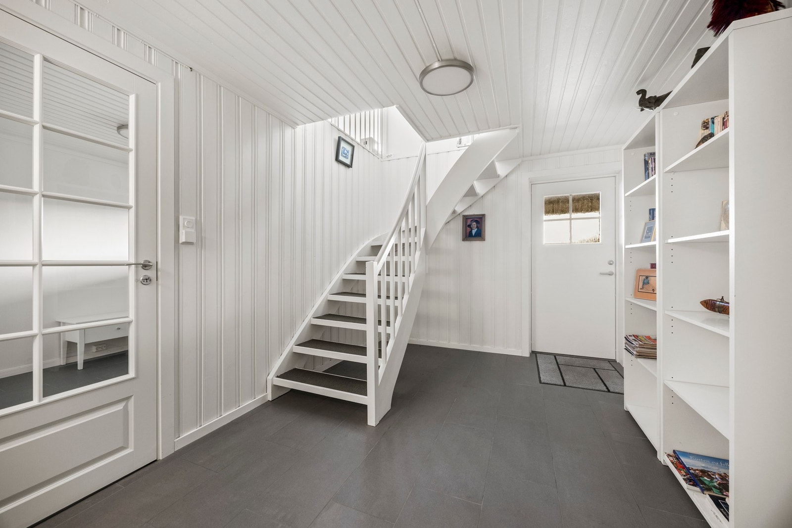 Gangen har egen ytterdør og flislagt gulv med varme. Galleribilde