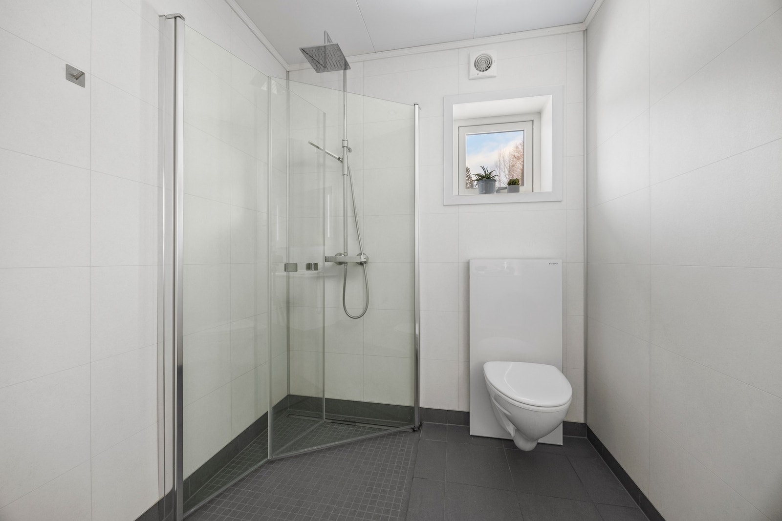 Badet er utstyrt med bl.a. servantskap, WC og dusjhjørne. Galleribilde