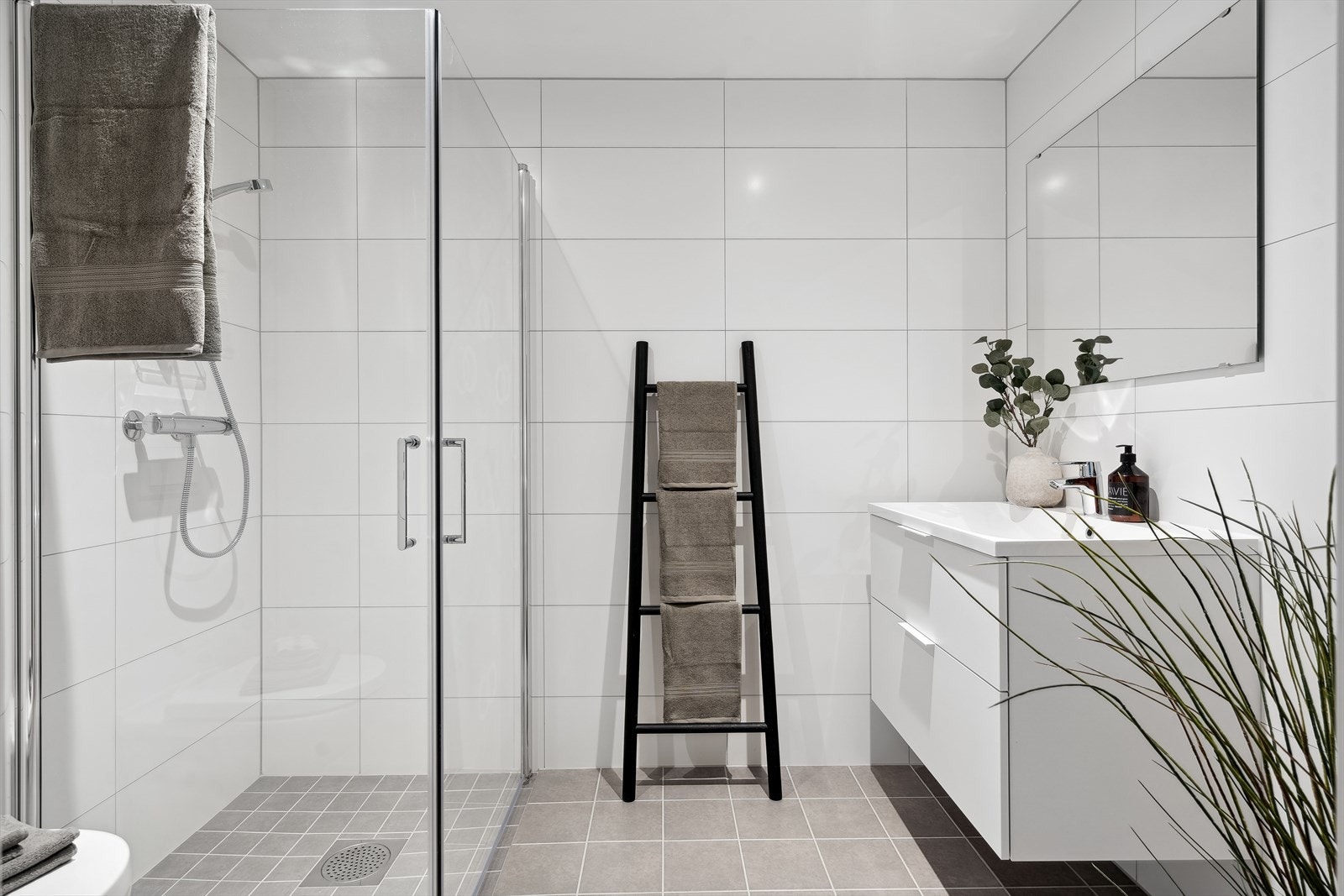 Lys og moderne baderomsinnredning. Opplegg for vaskemaskin Galleribilde