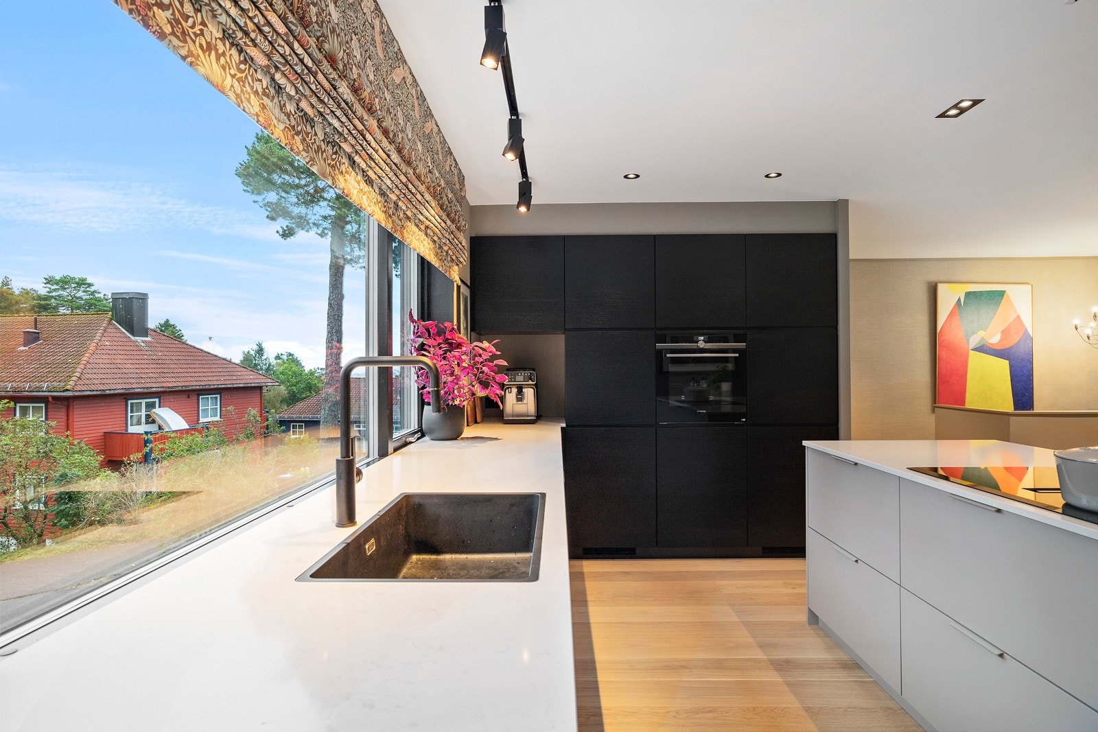 Oppvaskkummen er nedfelt i benk foran vinduene. Høyskapene har sorte finerfronter, mens benkeskap har glatte fronter. Galleribilde