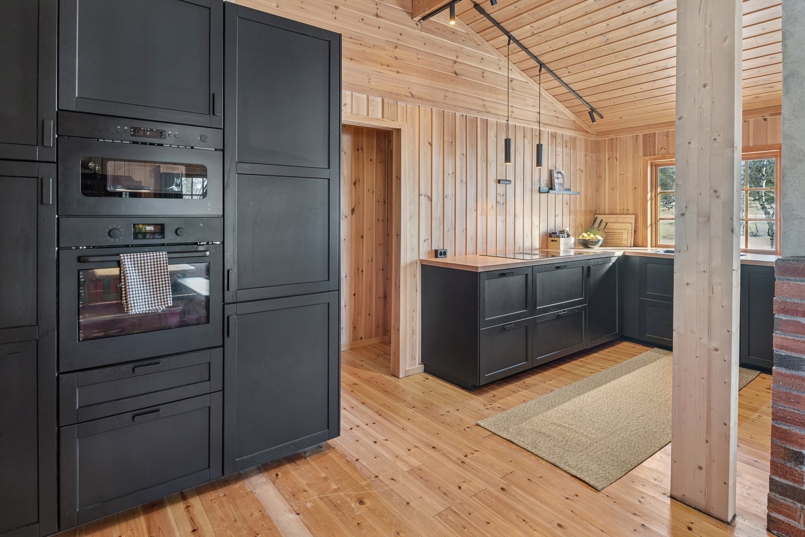 Kjøkkenet har integrerte hvitevarer i stilig, mørk utførelse. Galleribilde