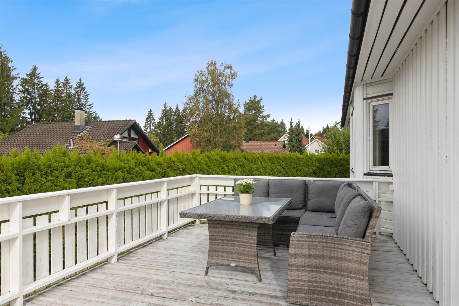 En stor terrasse som strekker seg rundt deler av boligen. Galleribilde