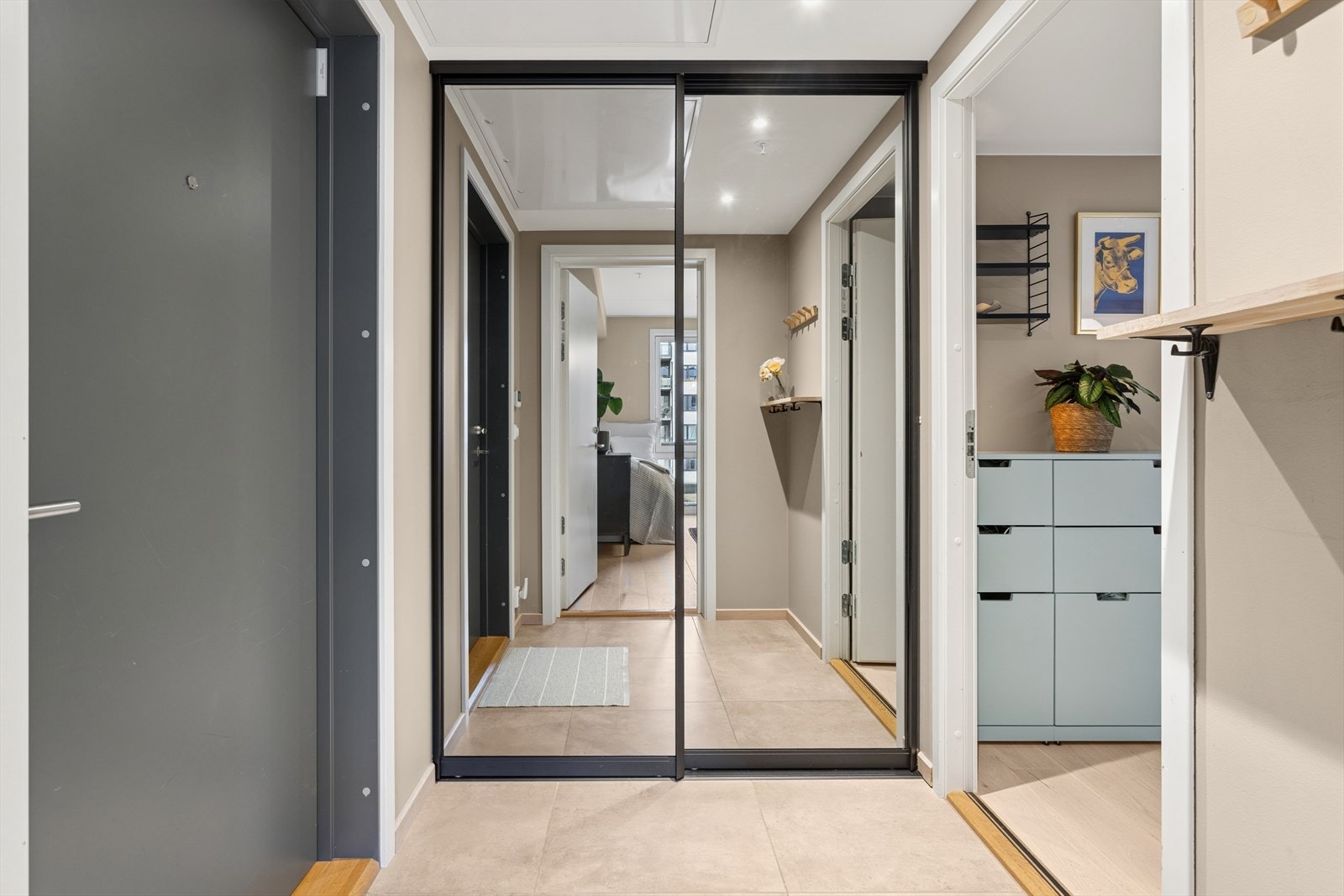 Herfra kommer man inn i en lys og innbydende entré hvor du raskt vil legge merke til leilighetens høye standard med pene og lyse veggflater. I entréen er det en stor skyvedørsgarderobe med speilfronter som gir rikelig med plass for oppbevaring. Galleribilde
