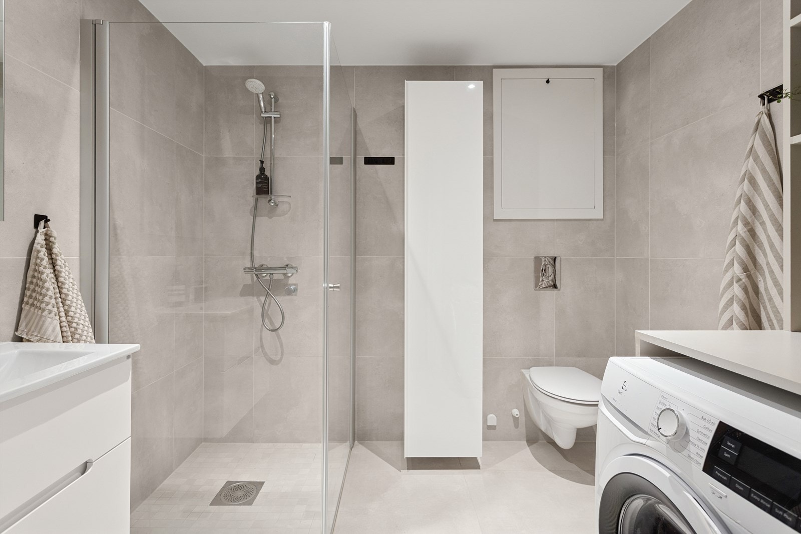 Det er også opplegg for vaskemaskin (smart hyllesystem er bygd over maskin for ekstra lagring). Ventilasjonen består av et balansert anlegg med avtrekk i himlingen. Hovedbadet har for øvrig kun fått TG1 fra takstmann. Galleribilde