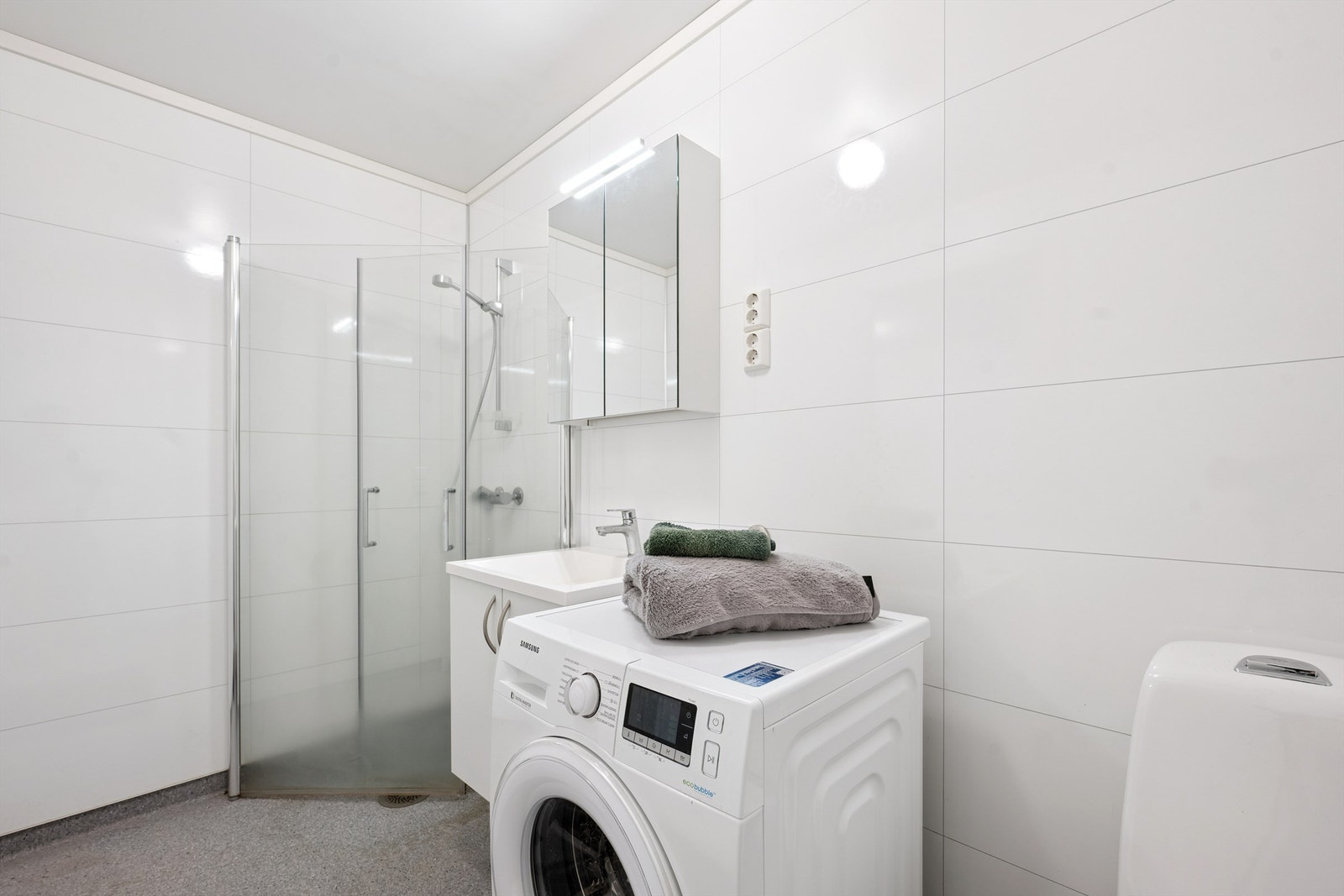 Badet har våtromsplater på veggene og opplegg for vaskemaskin. Galleribilde