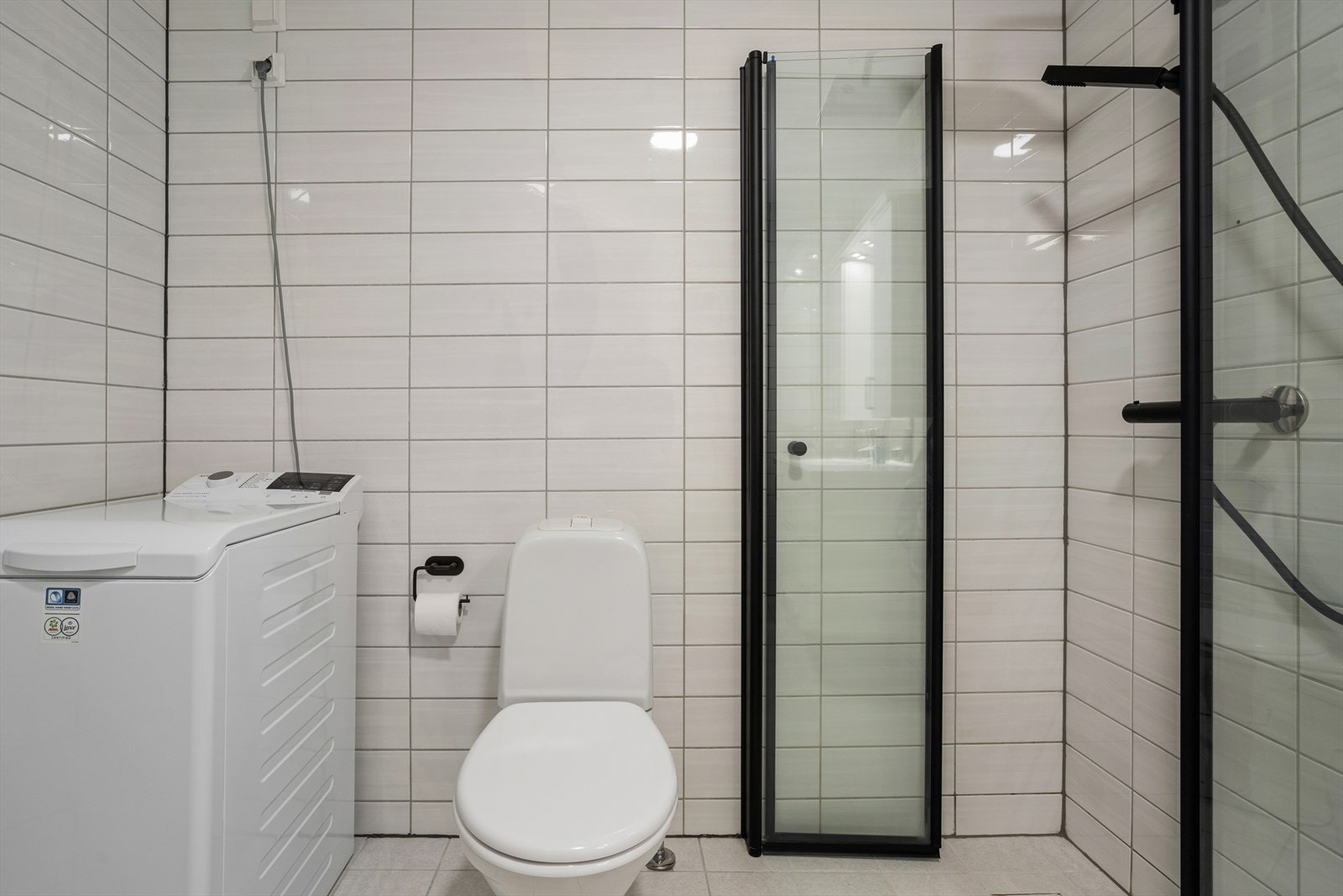 Badet er innredet med baderomsinnredning med heldekkende servant, speilskap med belysning, gulvmontert toalett og dusjhjørne med glassdører. Galleribilde