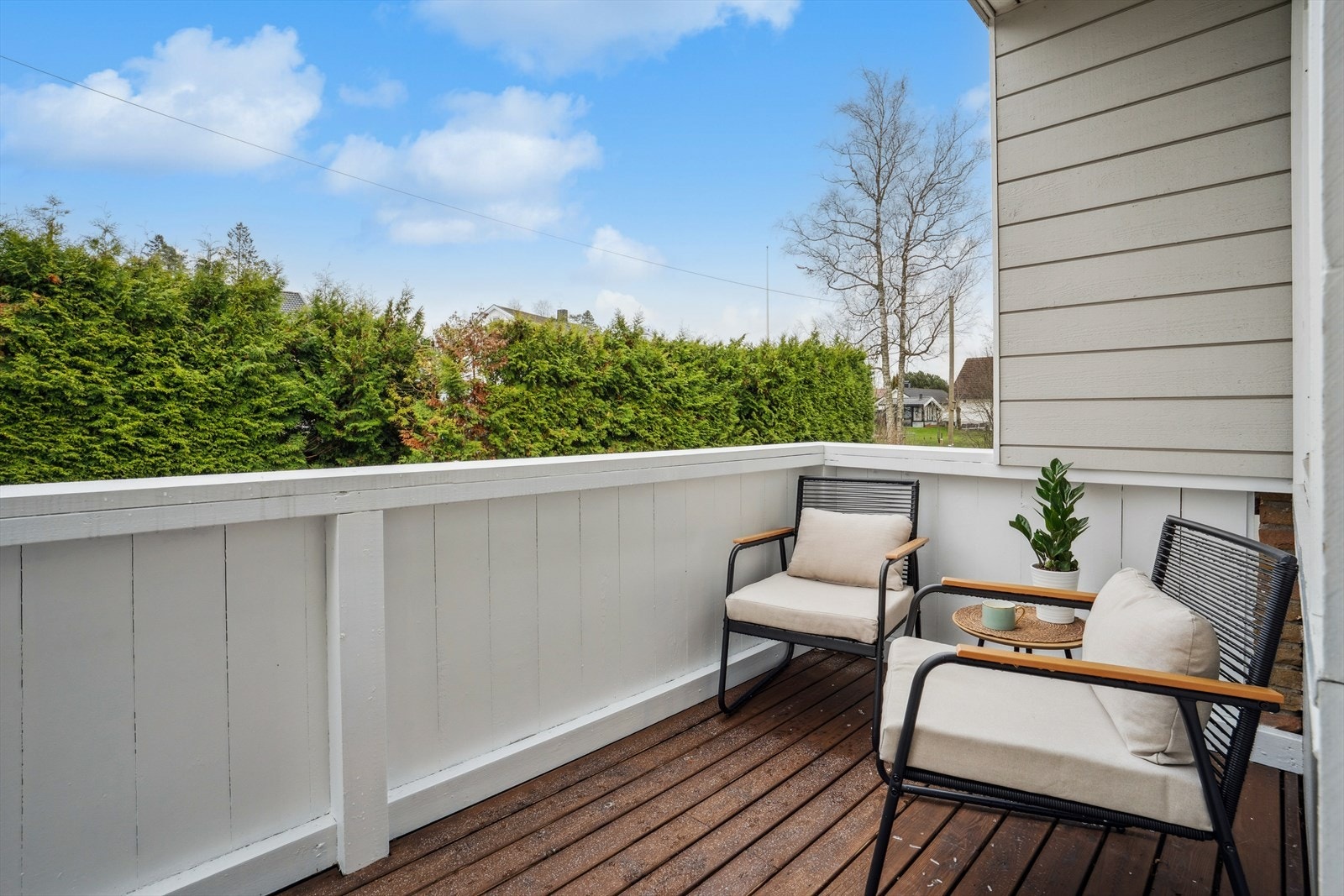 Balkongen er delvis overbygget og godt skjermet med vegger, noe som gir en lun og skjermet uteplass. Galleribilde