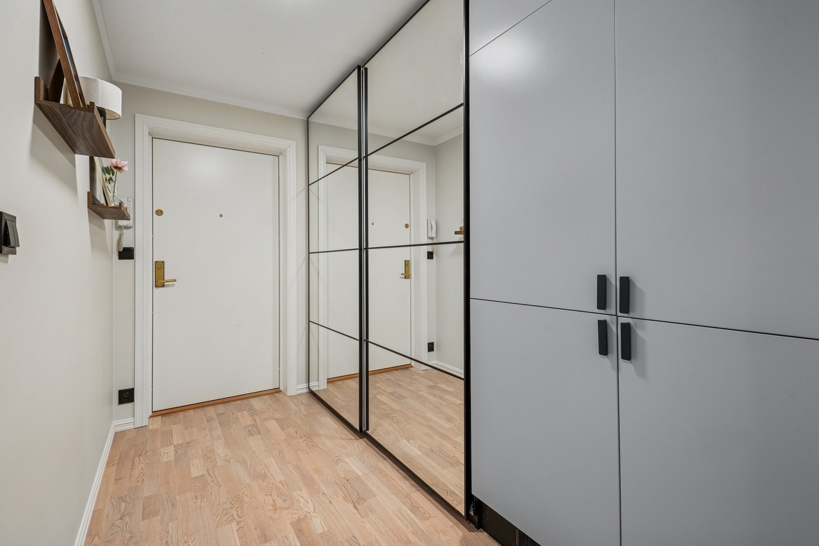 Entréen har pent parkettgulv og glatte vegger, noe som er gjennomgående i hele leiligheten. Galleribilde