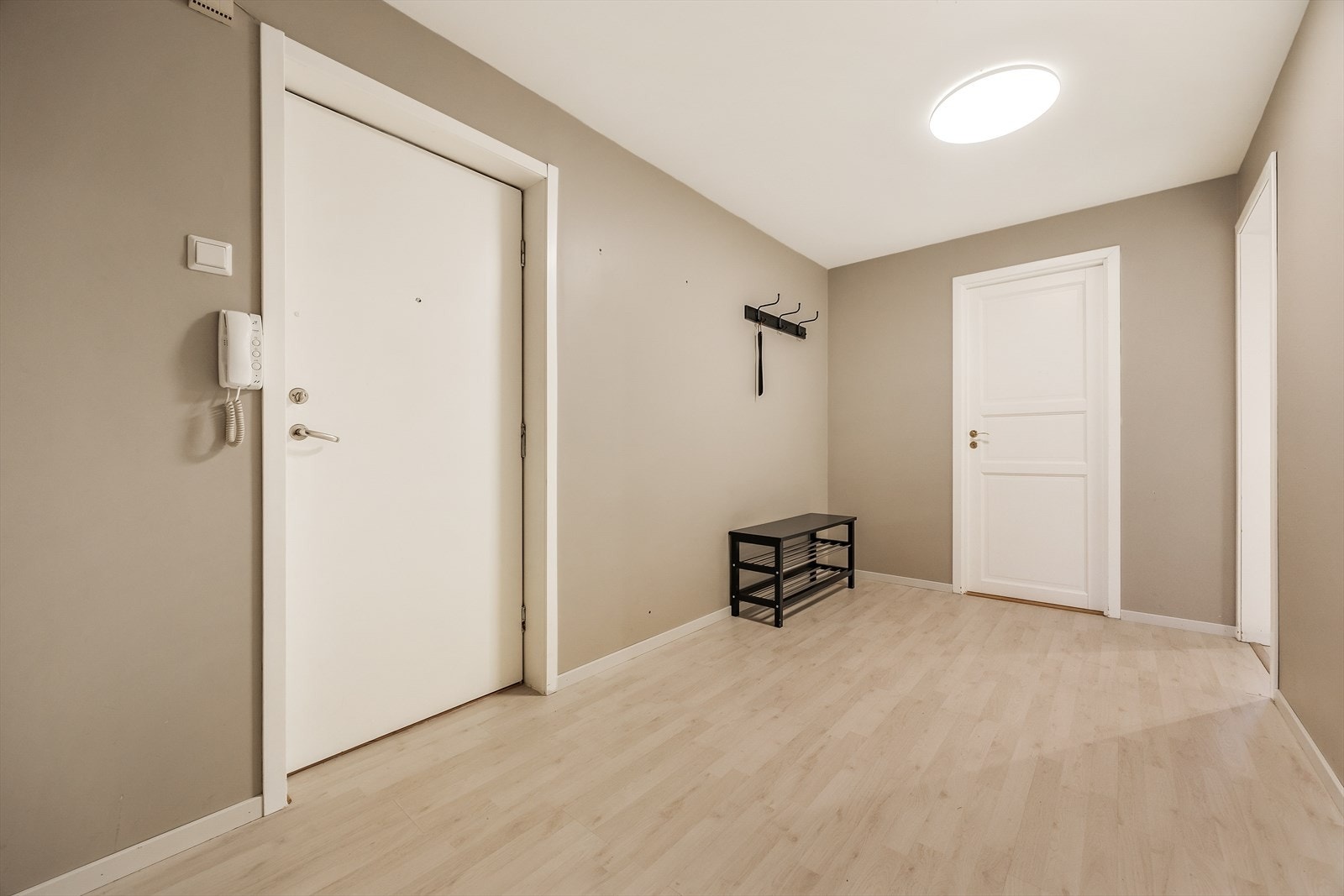 Gangen er utstyrt med dørtelefon og har profilerte dører som ble malt i 2022. Galleribilde