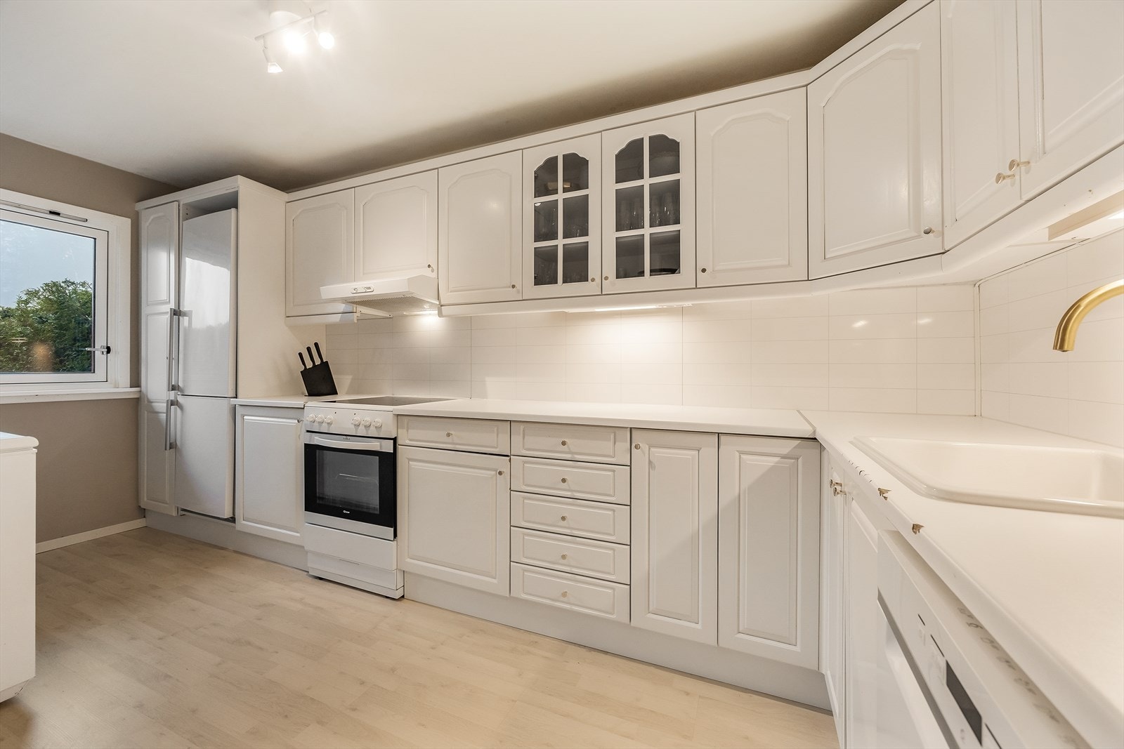 Kjøkkeninnredningen har godt med benke- og lagringsplass, inkludert vitrineskap. Galleribilde