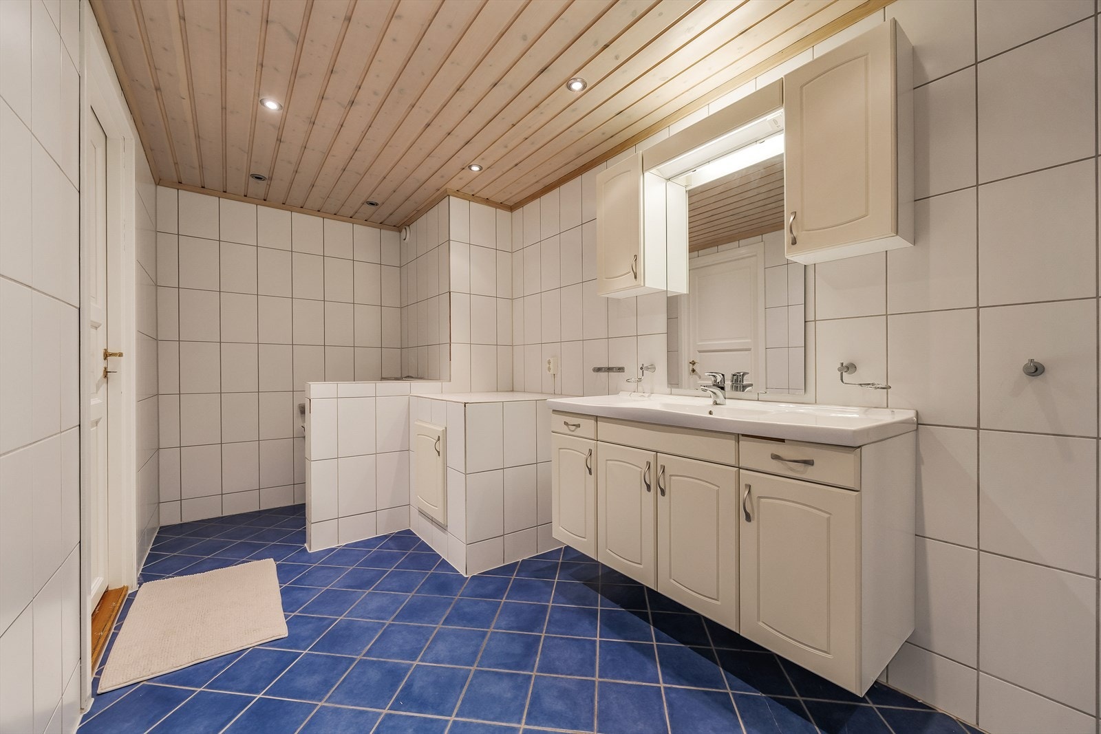 Badet er innredet med dusjkabinett og en bred servant med god skapplass. Galleribilde