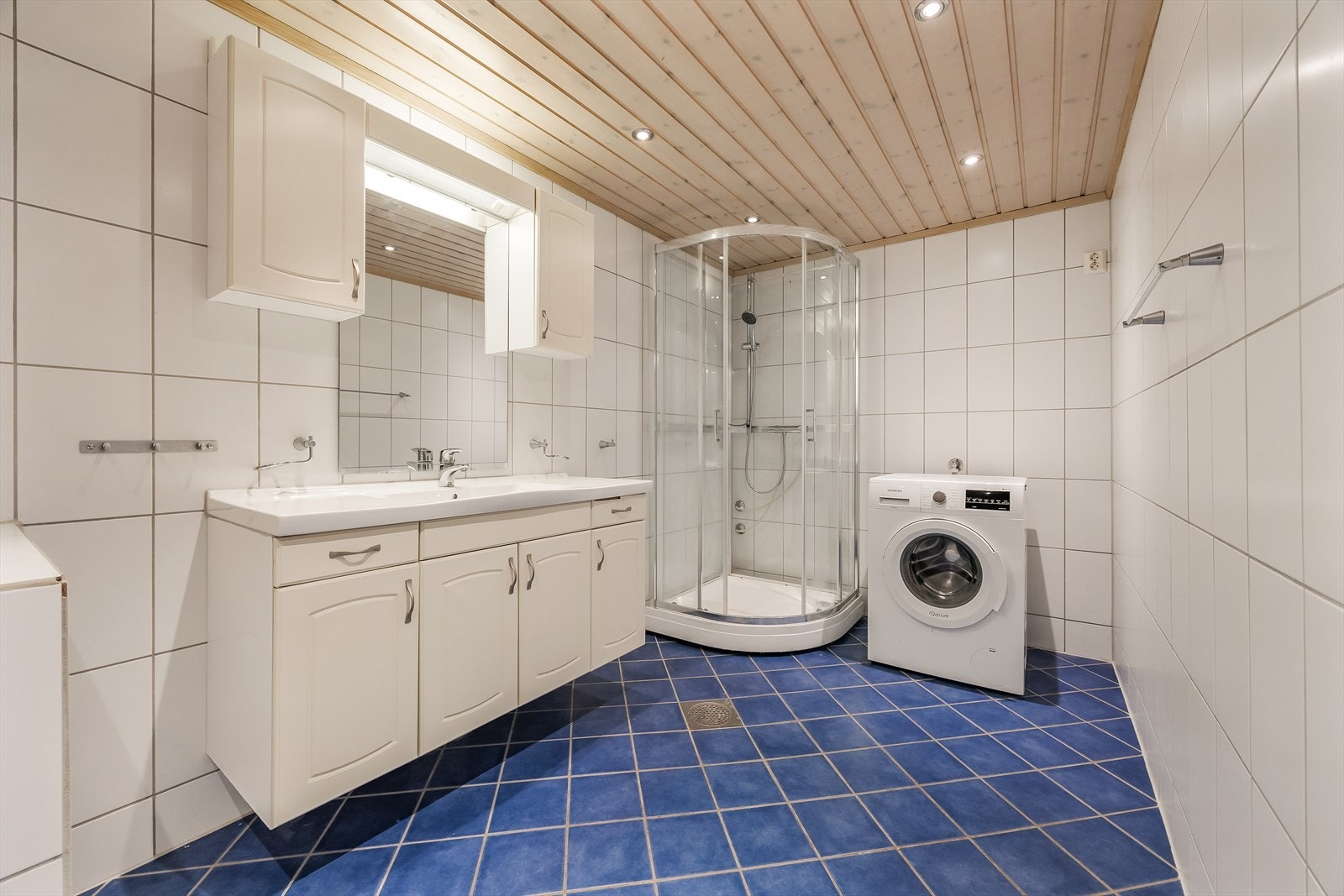 Romslig, flislagt bad med elektriske varmekabler i gulvet og opplegg for vaskemaskin. Galleribilde