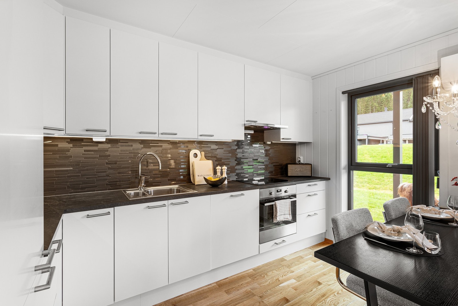 Lekkert kjøkken fra AUBO med pene fliser i bakkant. Rikelig med skap- og benkeplass. Galleribilde