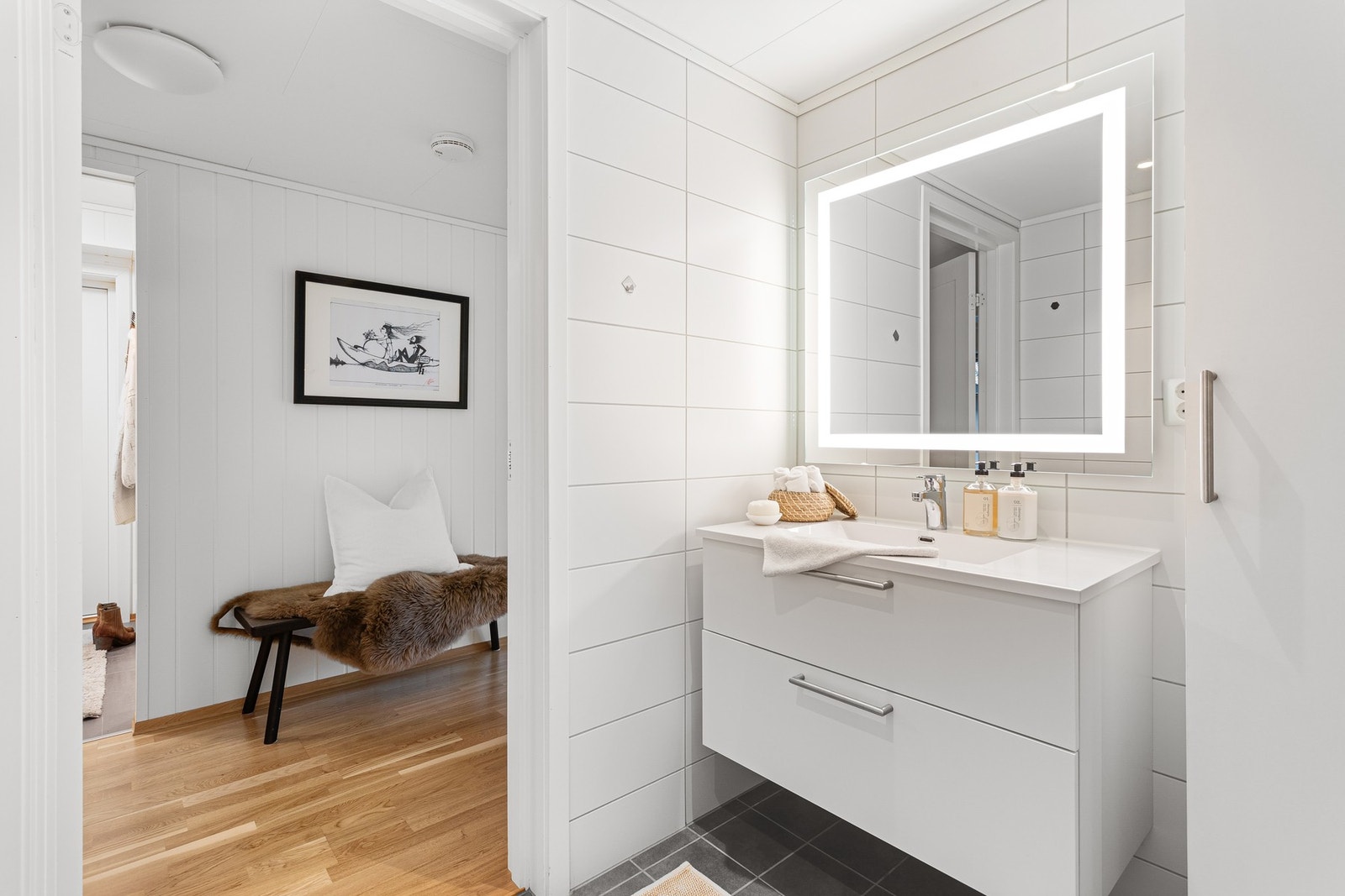 Badet har elektriske varmekabler i gulv. Av utstyr finnes servant med underskap, veggskap og speil, vegghengt toalett og dusjnisje. Galleribilde