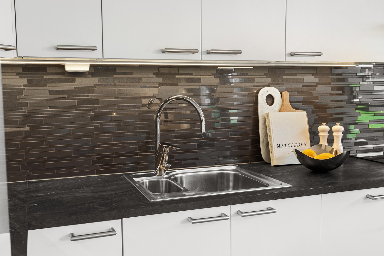 Av utstyr finnes kjøkkeninnredning med plane fronter og laminerte benkeplater, ventilator, integrert platetopp, stekeovn kjø/frys og oppvaskmaskin. Galleribilde