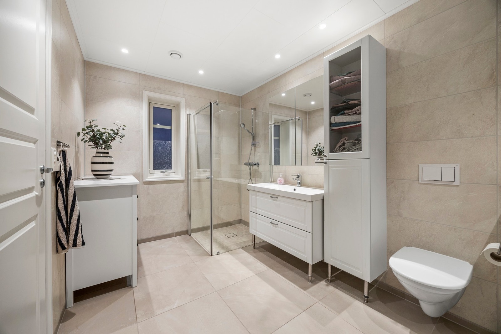 Utstyrt med dusjdører, servantskap, høgskap, toalett og opplegg for vaskemaskin Galleribilde