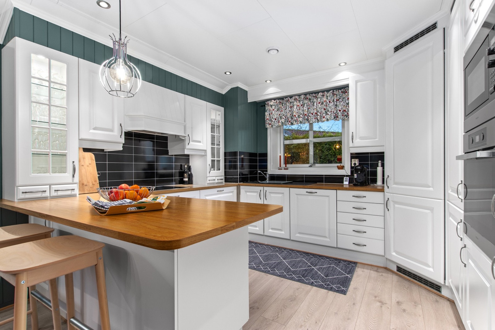 Romslig kjøkken med innbygde hvitevarer og kjølehjørnet. Galleribilde