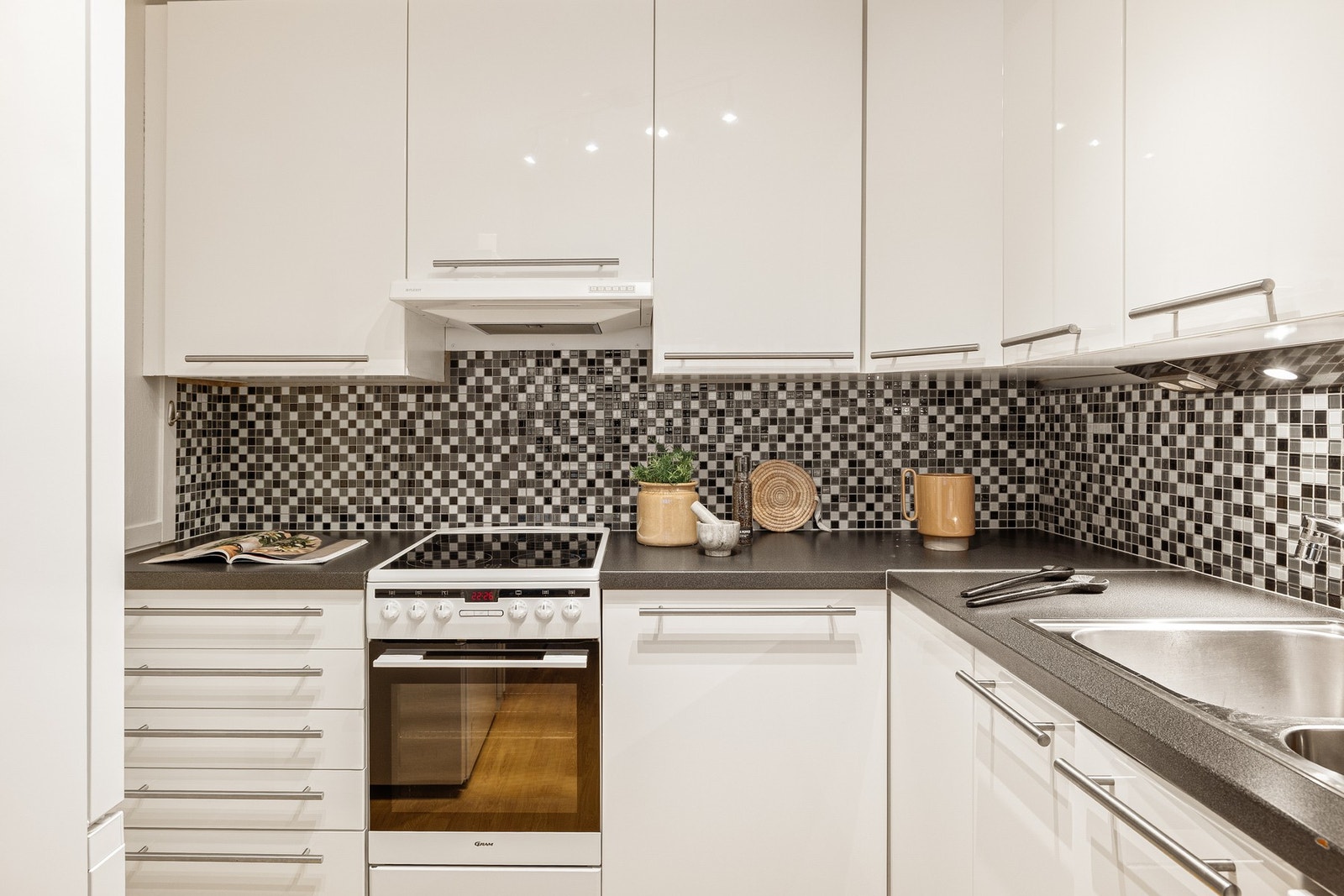 Velholdt og tidløst kjøkken innredet med slette fronter og laminert benkeplate Galleribilde