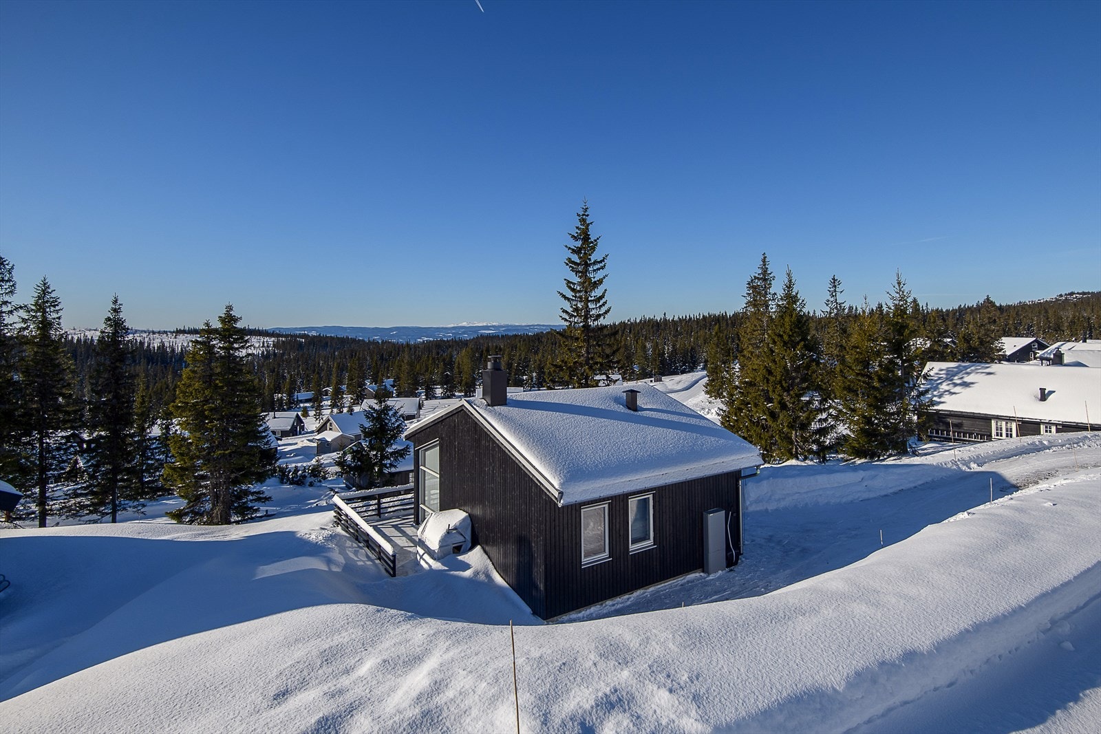 Enkel adkomst til hytta fra interne veier i feltet. Gruset biloppstillingsplass foran hytta. Galleribilde