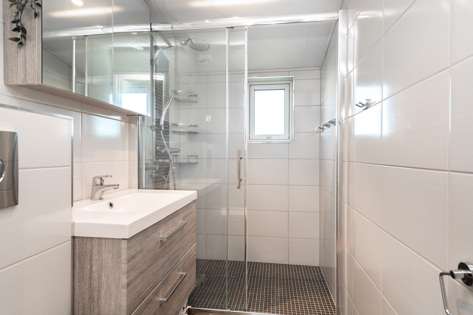 Pent flislagt bad med dusjnisje og vegghengt WC Galleribilde