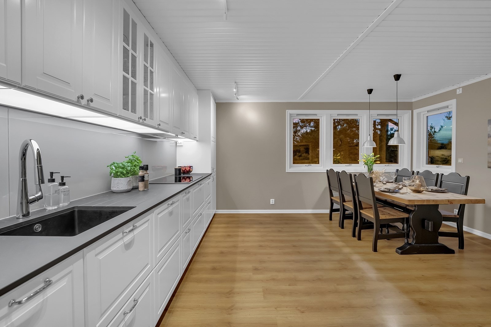 Kjøkkenet er romslig og har godt med skap- og benkeplass, og de store vinduene gir en lys og trivelig atmosfære. Det er rikelig plass til langbord som rommer både familie og gjester. Galleribilde