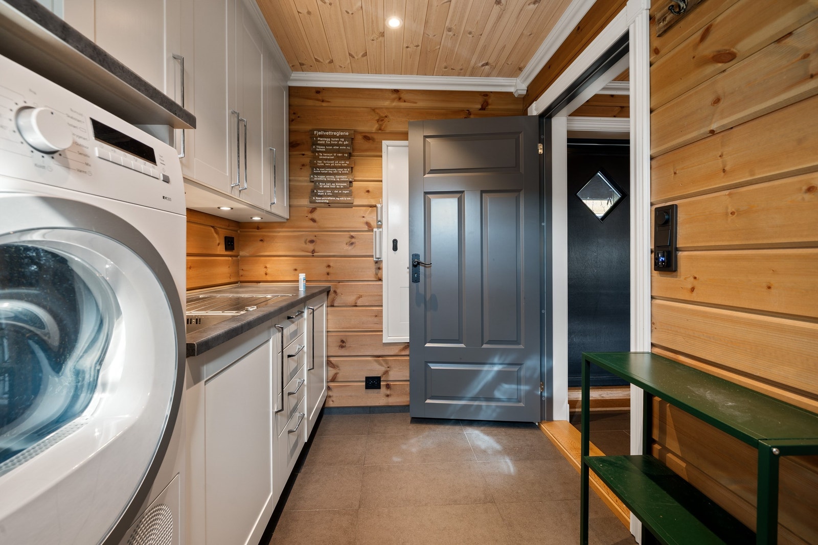 Vaskerommet, fliser på gulv, varmekabler, flott beiset panel på vegg. Galleribilde