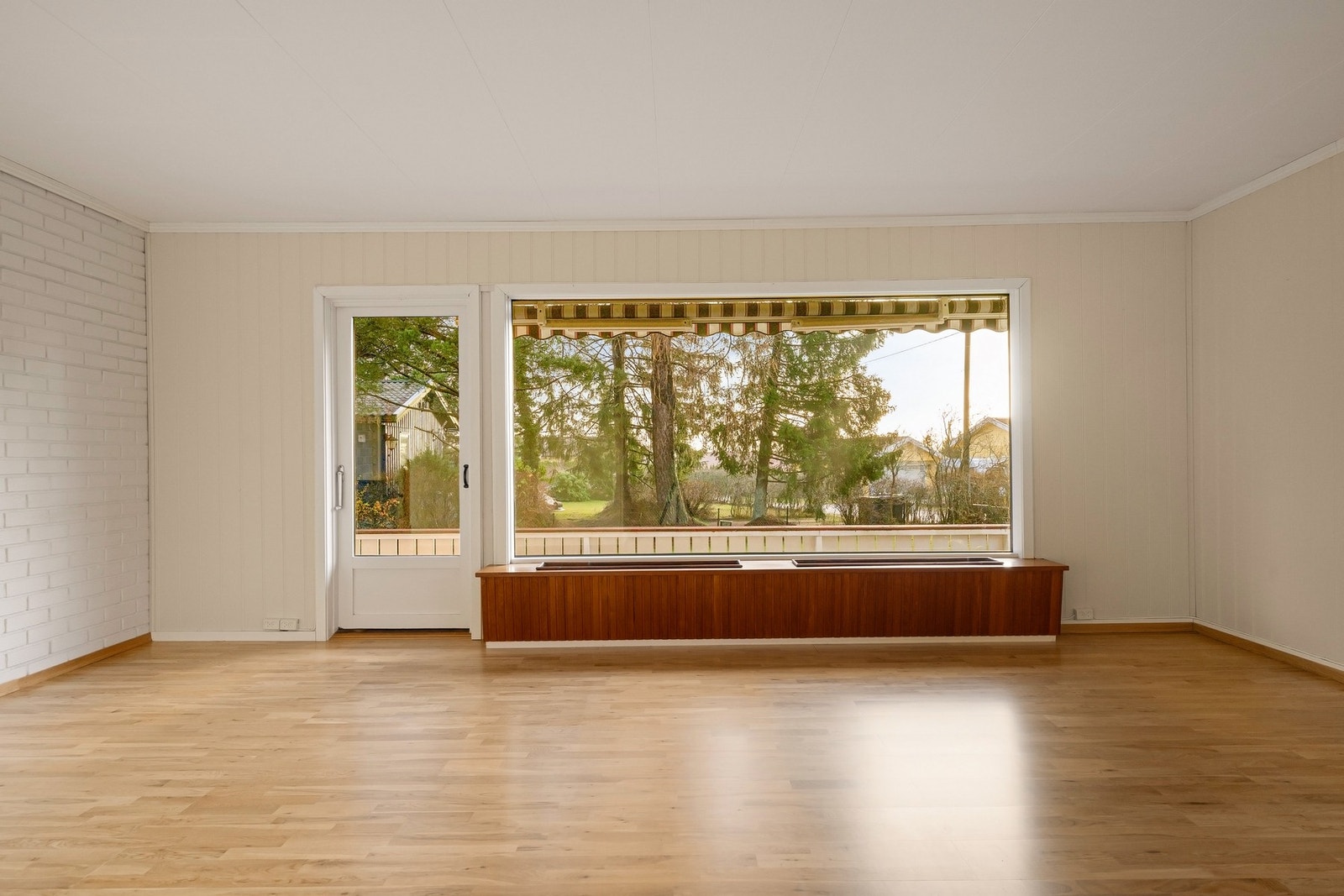 En romslig stue med vinduer som rammer inn omgivelsene utenfor Galleribilde